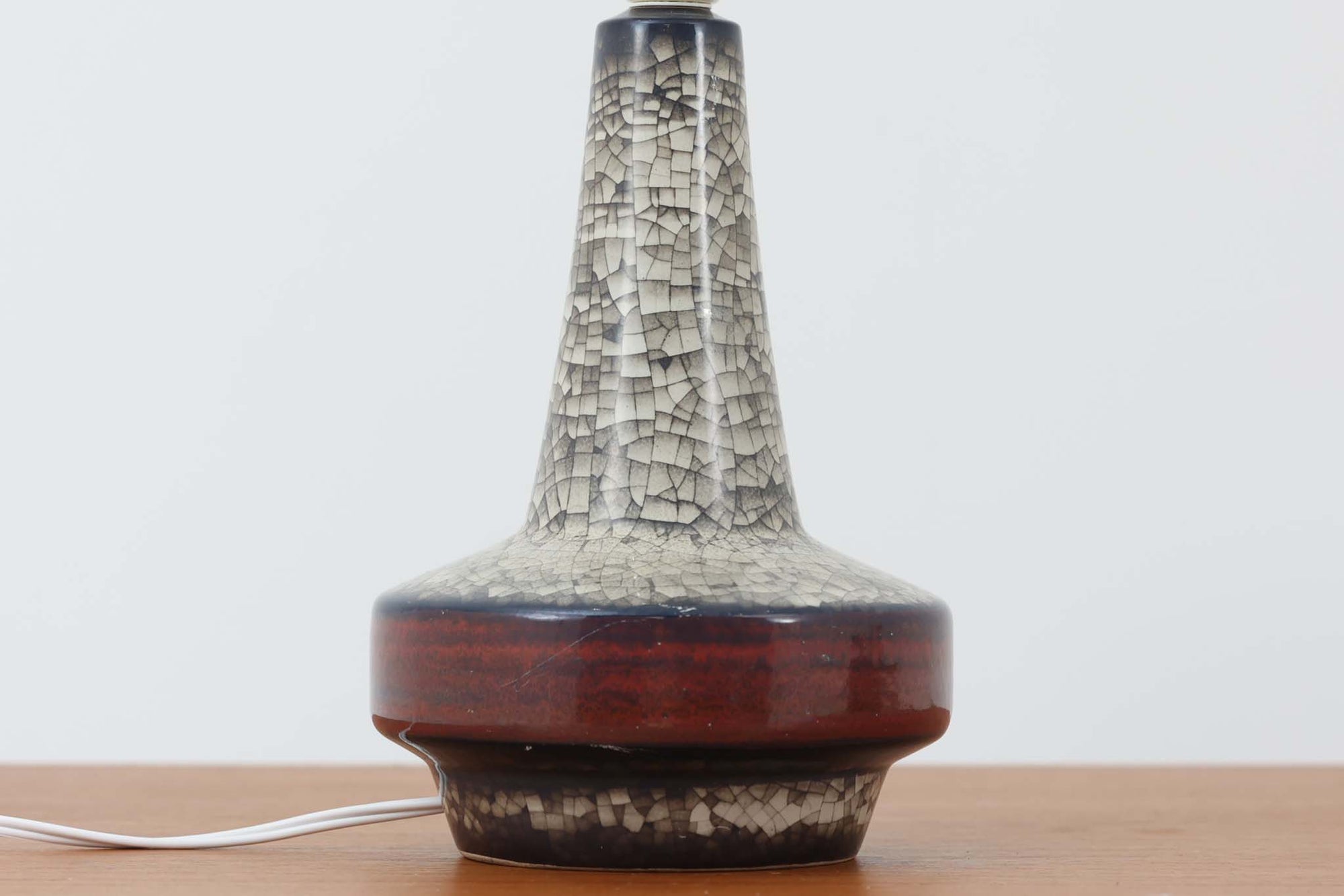 デンマーク・ボーンホルム島の老舗陶器メーカー、michael Andersen &amp; Sonによるテーブルランプ。細やかな貫入模様と深みのある釉薬の色合いが特徴で、ベース部分は温かみのあるクラフト感を漂わせています。シェードは新品のリネン製で、やさしく光を拡散し、空間に柔らかな雰囲気をもたらします。北欧ヴィンテージらしい造形美と素材感を楽しめる一点です。