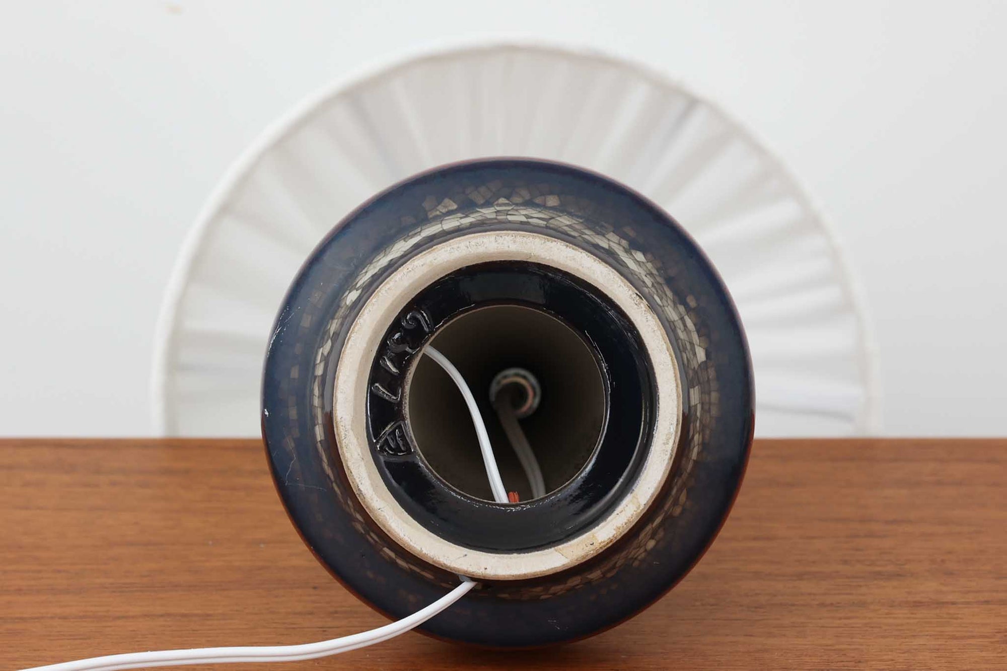 デンマーク・ボーンホルム島の老舗陶器メーカー、michael Andersen &amp; Sonによるテーブルランプ。細やかな貫入模様と深みのある釉薬の色合いが特徴で、ベース部分は温かみのあるクラフト感を漂わせています。シェードは新品のリネン製で、やさしく光を拡散し、空間に柔らかな雰囲気をもたらします。北欧ヴィンテージらしい造形美と素材感を楽しめる一点です。