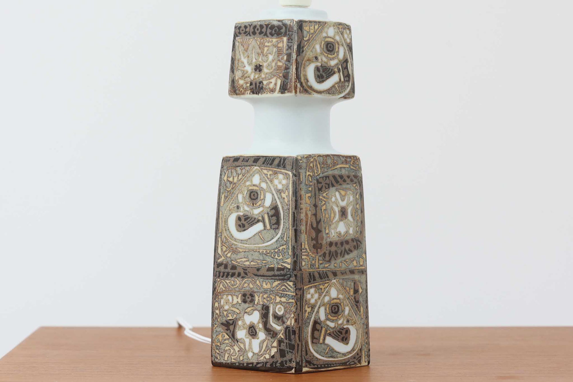 Royal Copenhagen製のベースが使用されたテーブルランプです。製造年数（1965〜1970年代）も少なく、現在では入手困難な希少モデルとなっています。現在の製造方法とは異なり、ファイアンス釜で作られた陶器ならではの独特な風合いが魅力で、ヴィンテージ品としての価値も高い一点です。ベースの柄は自然をモチーフとしたNils Thorssonによる人気のBACAシリーズで、職人の手作業によるフリーハンドで描かれているため、ひとつとして同じものが存在しない点もRoyal Copenhagenならではの魅力です。高さは約50cmとやや大きめで、インテリアのアクセントとしても存在感があり、オブジェのようにお部屋をおしゃれに演出してくれます。