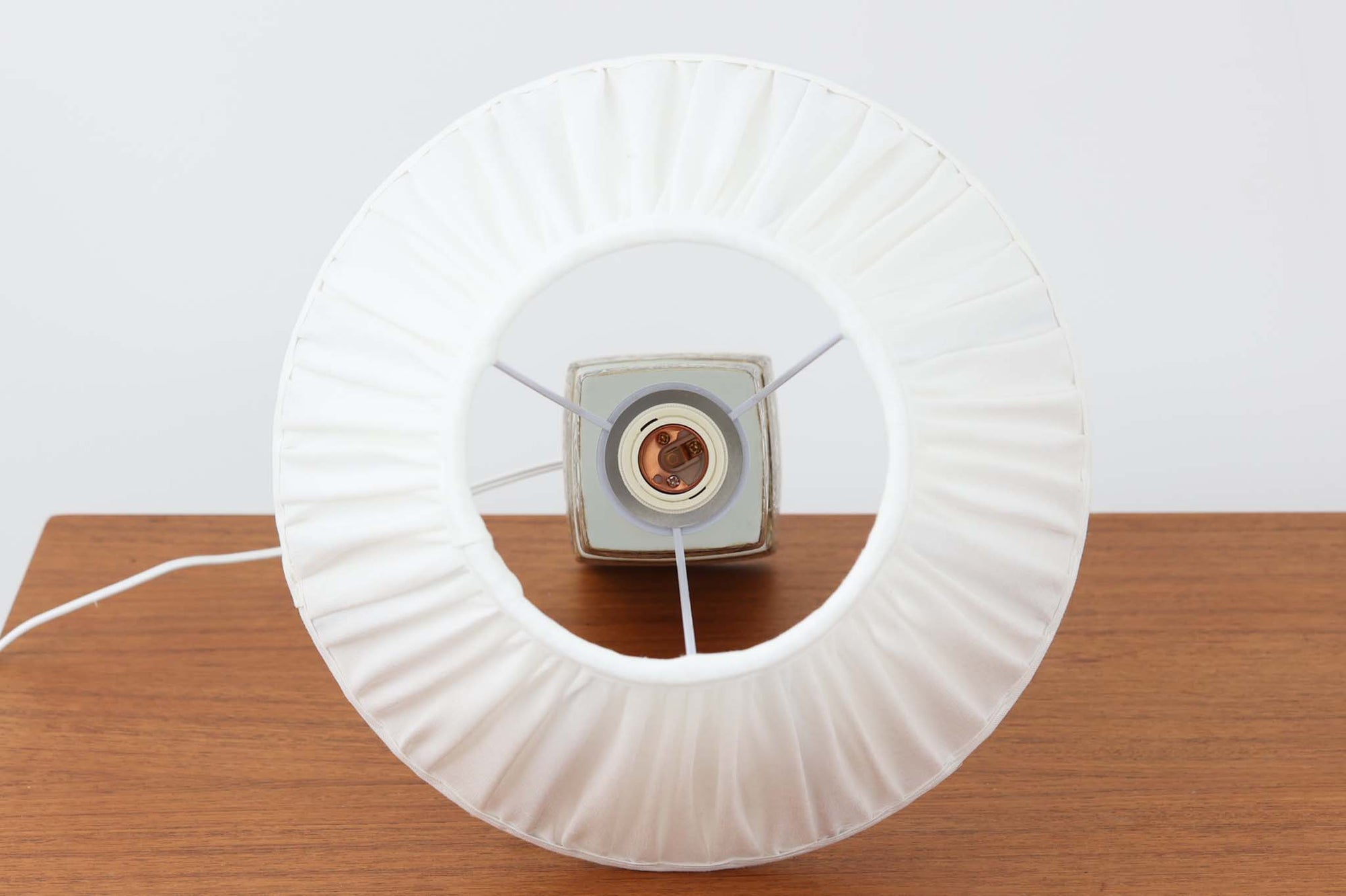 Royal Copenhagen製のベースが使用されたテーブルランプです。製造年数（1965〜1970年代）も少なく、現在では入手困難な希少モデルとなっています。現在の製造方法とは異なり、ファイアンス釜で作られた陶器ならではの独特な風合いが魅力で、ヴィンテージ品としての価値も高い一点です。ベースの柄は自然をモチーフとしたNils Thorssonによる人気のBACAシリーズで、職人の手作業によるフリーハンドで描かれているため、ひとつとして同じものが存在しない点もRoyal Copenhagenならではの魅力です。高さは約50cmとやや大きめで、インテリアのアクセントとしても存在感があり、オブジェのようにお部屋をおしゃれに演出してくれます。