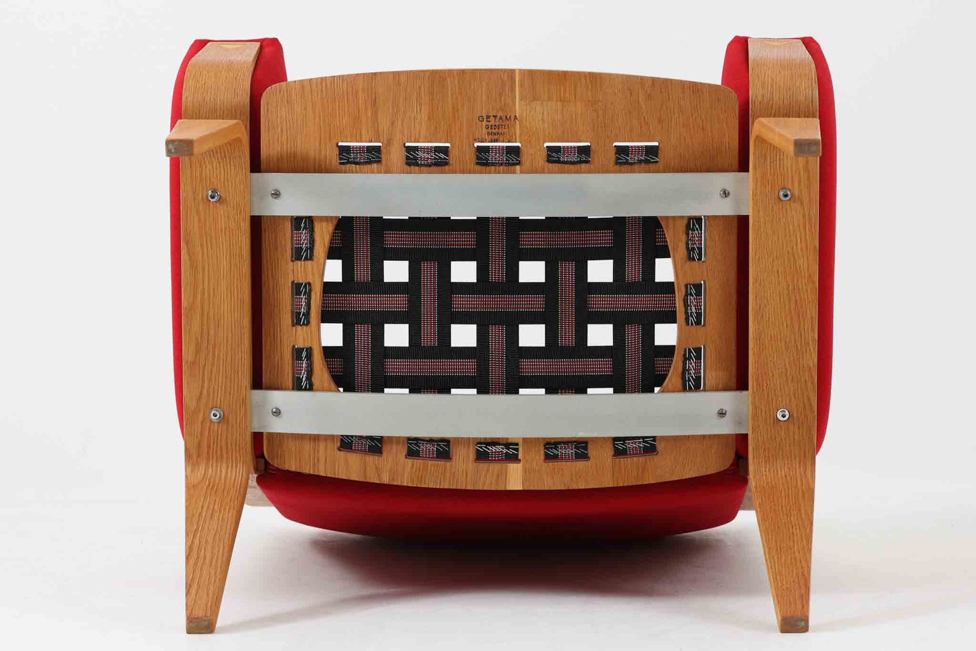 Hans J. Wegner（ハンス・J・ウェグナー）が1960年代にデザインし、Getama（ゲタマ）社によって製造されたGE501Aモデルのハイバックシングルソファ。当時としては珍しく、フレームにプライウッドが使用されています。フレームには堅牢で美しい木目を持つオーク材を使用し、直線と曲線が融合した造形が北欧家具らしい洗練された印象を与えます。張地には鮮やかな赤のファブリックを使用し、空間にアクセントを添えると同時に、快適性と耐久性も兼ね備えた仕上がりです。ヴィンテージならではの存在感と高い実用性を兼ね備えた一脚として、リビングや読書スペースに最適です。