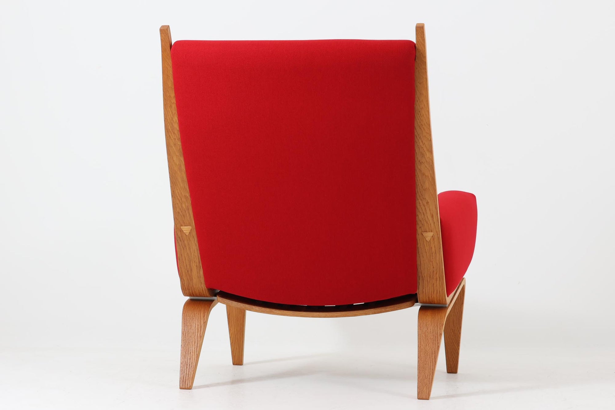 Hans J. Wegner（ハンス・J・ウェグナー）が1960年代にデザインし、Getama（ゲタマ）社によって製造されたGE501Aモデルのハイバックシングルソファ。当時としては珍しく、フレームにプライウッドが使用されています。フレームには堅牢で美しい木目を持つオーク材を使用し、直線と曲線が融合した造形が北欧家具らしい洗練された印象を与えます。張地には鮮やかな赤のファブリックを使用し、空間にアクセントを添えると同時に、快適性と耐久性も兼ね備えた仕上がりです。ヴィンテージならではの存在感と高い実用性を兼ね備えた一脚として、リビングや読書スペースに最適です。