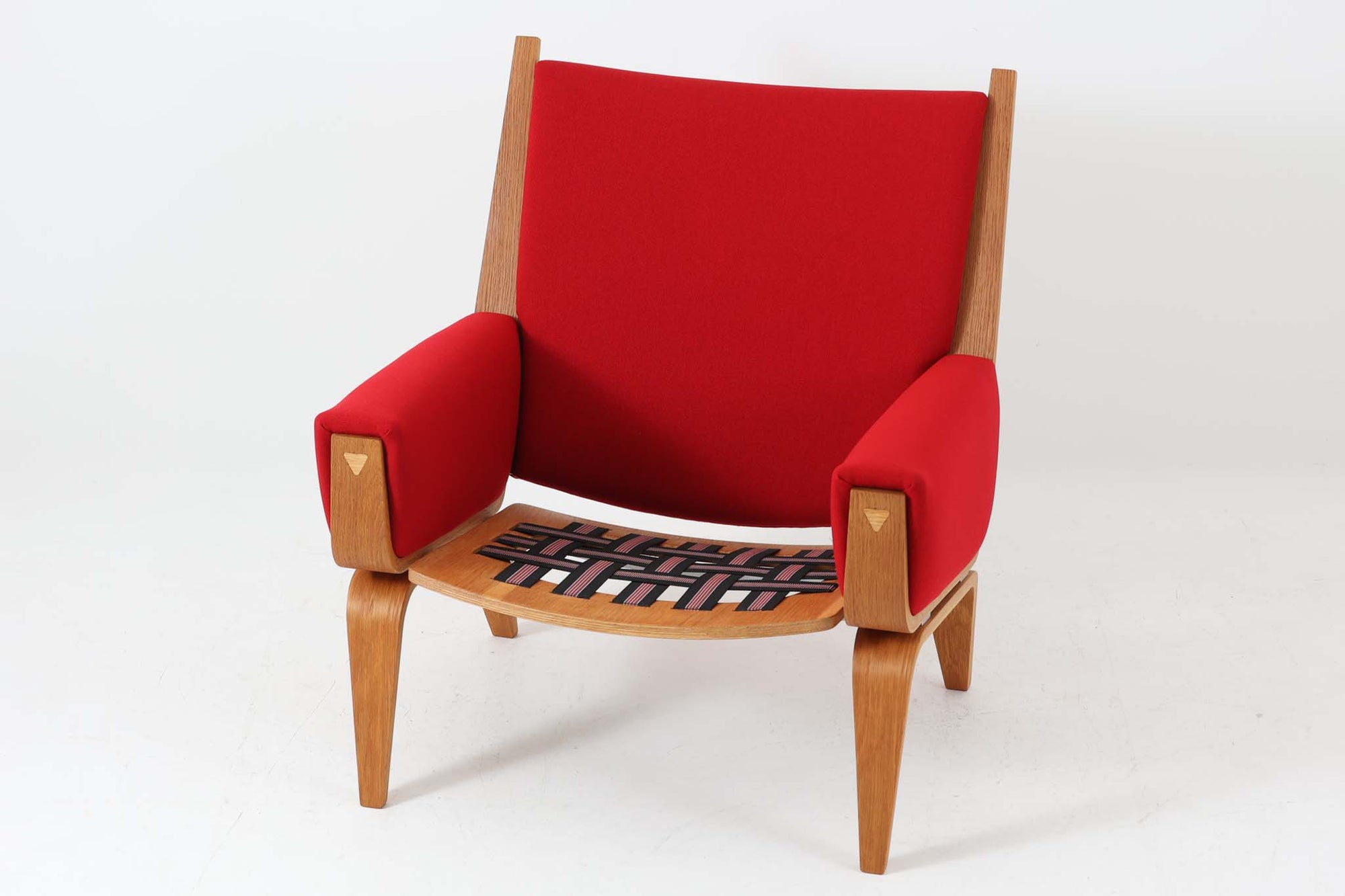 Hans J. Wegner（ハンス・J・ウェグナー）がGetama（ゲタマ）社のために1960年代にデザインしたGE501モデルのシングルソファ。当時としては珍しく、フレームにプライウッドが使用されています。素材には堅牢で美しい木目のオーク材を使用し、特徴的なアームの加工や緩やかなフレームラインなど、ウェグナーならではのディテールが際立ちます。張地は鮮やかな赤いファブリックに張替え済みで、空間に華やかさを添えつつ、ビンテージならではの存在感と温もりが感じられる一脚です。