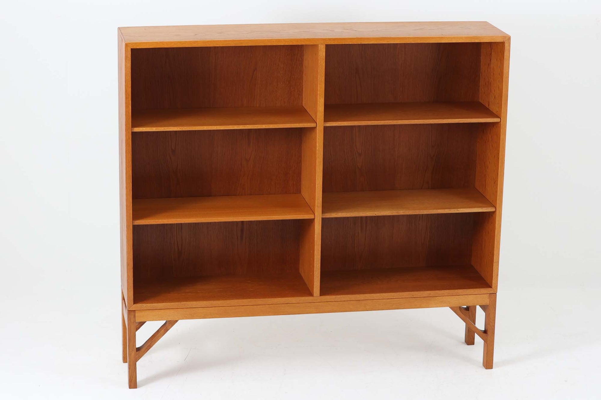 デンマークの名門FDB社より製造された、ボーエ・モーエンセンデザインのヴィンテージブックシェルフ。北欧家具の巨匠であるモーエンセンならではの機能美が際立つ、シンプルかつ実用的なデザインが特徴です。素材には温かみのあるオーク材を使用し、しっかりとした構造と美しい木目が魅力。直線的なフォルムに加え、脚部にはさりげなくデザイン性を加えた補強パーツが施され、安定感と視覚的な軽やかさを両立しています。広々とした収納スペースは書籍や雑貨の収納に最適で、シンプルながらも存在感のあるデザインはリビングや書斎、寝室など幅広い空間に調和します。FDB社のクラフトマンシップが息づく、北欧ヴィンテージの逸品をお楽しみください。脚はビンテージのオリジナル品です。