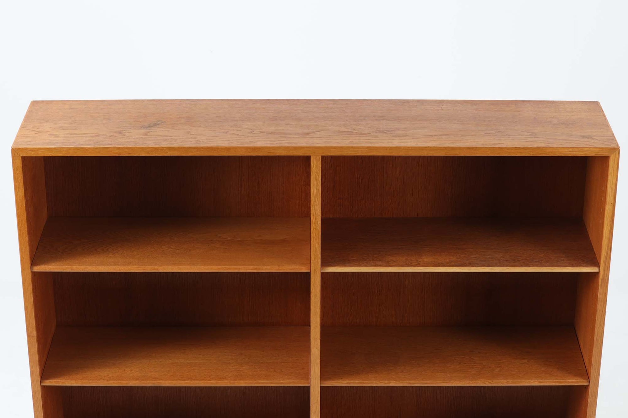 デンマークの名門FDB社より製造された、ボーエ・モーエンセンデザインのヴィンテージブックシェルフ。北欧家具の巨匠であるモーエンセンならではの機能美が際立つ、シンプルかつ実用的なデザインが特徴です。素材には温かみのあるオーク材を使用し、しっかりとした構造と美しい木目が魅力。直線的なフォルムに加え、脚部にはさりげなくデザイン性を加えた補強パーツが施され、安定感と視覚的な軽やかさを両立しています。広々とした収納スペースは書籍や雑貨の収納に最適で、シンプルながらも存在感のあるデザインはリビングや書斎、寝室など幅広い空間に調和します。FDB社のクラフトマンシップが息づく、北欧ヴィンテージの逸品をお楽しみください。脚はビンテージのオリジナル品です。