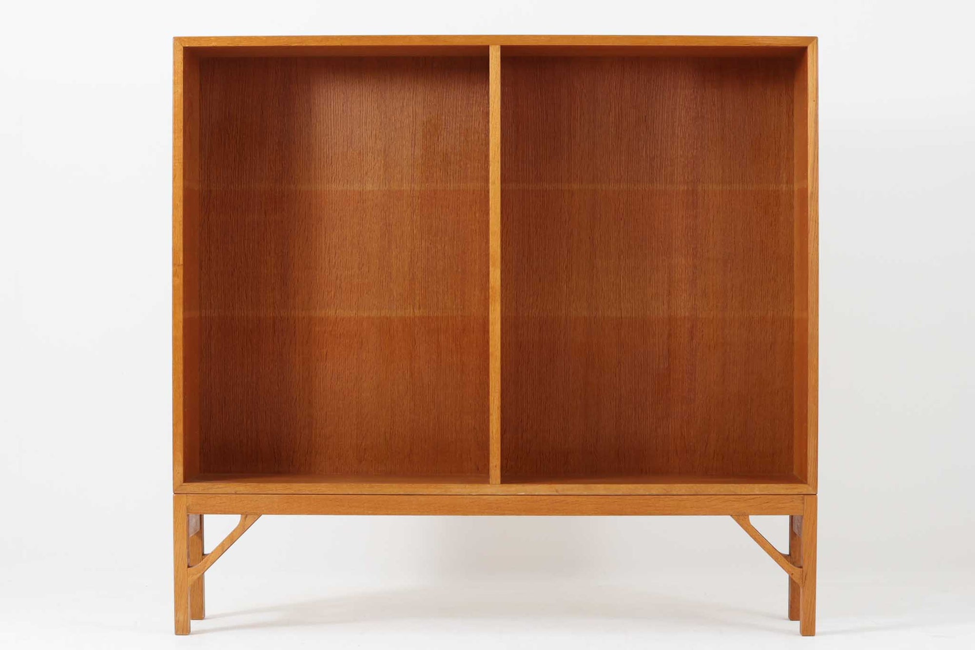 デンマークの名門FDB社より製造された、ボーエ・モーエンセンデザインのヴィンテージブックシェルフ。北欧家具の巨匠であるモーエンセンならではの機能美が際立つ、シンプルかつ実用的なデザインが特徴です。素材には温かみのあるオーク材を使用し、しっかりとした構造と美しい木目が魅力。直線的なフォルムに加え、脚部にはさりげなくデザイン性を加えた補強パーツが施され、安定感と視覚的な軽やかさを両立しています。広々とした収納スペースは書籍や雑貨の収納に最適で、シンプルながらも存在感のあるデザインはリビングや書斎、寝室など幅広い空間に調和します。FDB社のクラフトマンシップが息づく、北欧ヴィンテージの逸品をお楽しみください。脚はビンテージのオリジナル品です。