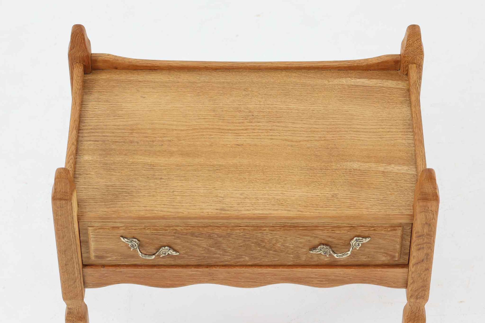 デンマークのデザイナー、Henning Kjaernulfによってデザインされたヴィンテージのサイドチェスト。素材には、木目の美しいオーク材が用いられており、しっかりとした存在感と温かみを感じさせます。脚部や幕板には柔らかな曲線が施され、ケアヌルフらしい彫刻的なフォルムが印象的。天板の縁や引き出しの装飾的なハンドルにもクラフトマンシップが光ります。引き出し1杯のシンプルな構造ながら、細部にこだわった造形が空間に個性を添える一台。ベッドサイドはもちろん、玄関先やリビングにもおすすめのアイテムです。