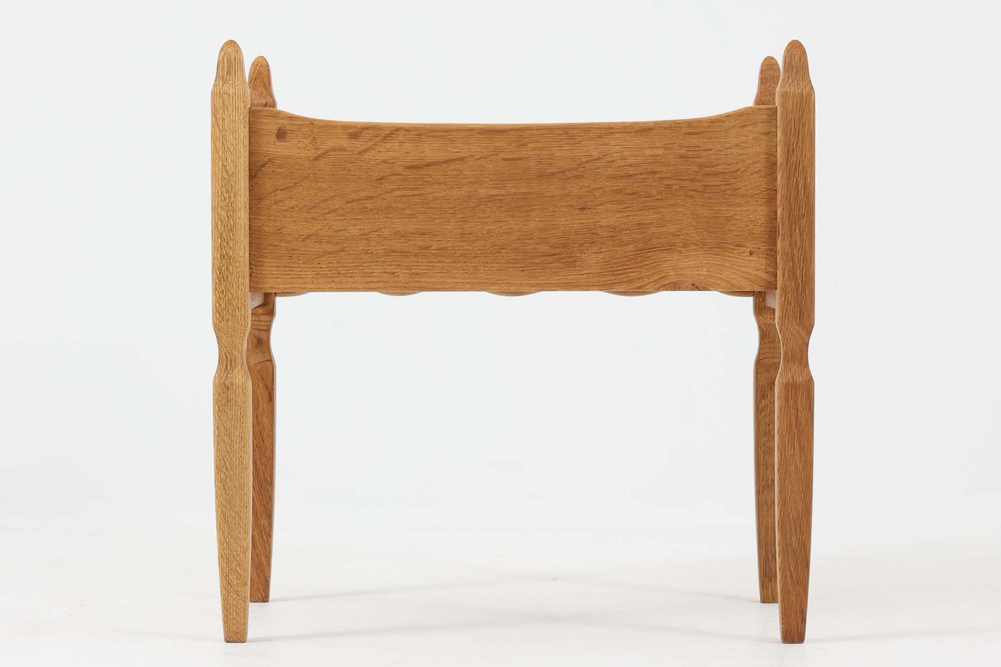 デンマークのデザイナー、Henning Kjaernulfによってデザインされたヴィンテージのサイドチェスト。素材には、木目の美しいオーク材が用いられており、しっかりとした存在感と温かみを感じさせます。脚部や幕板には柔らかな曲線が施され、ケアヌルフらしい彫刻的なフォルムが印象的。天板の縁や引き出しの装飾的なハンドルにもクラフトマンシップが光ります。引き出し1杯のシンプルな構造ながら、細部にこだわった造形が空間に個性を添える一台。ベッドサイドはもちろん、玄関先やリビングにもおすすめのアイテムです。