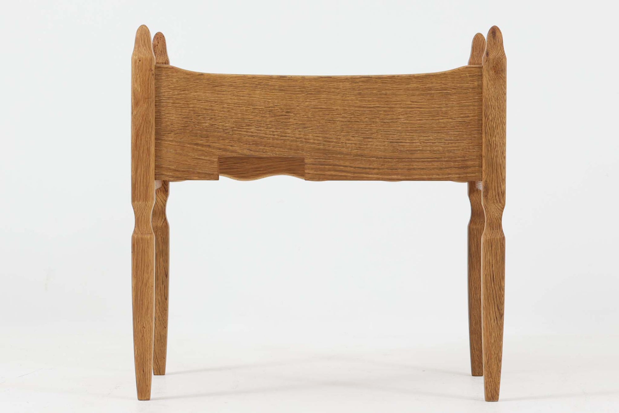 デンマークのデザイナー、Henning Kjaernulfによってデザインされたヴィンテージのサイドチェスト。素材には、木目の美しいオーク材が用いられており、しっかりとした存在感と温かみを感じさせます。脚部や幕板には柔らかな曲線が施され、ケアヌルフらしい彫刻的なフォルムが印象的。天板の縁や引き出しの装飾的なハンドルにもクラフトマンシップが光ります。引き出し1杯のシンプルな構造ながら、細部にこだわった造形が空間に個性を添える一台。ベッドサイドはもちろん、玄関先やリビングにもおすすめのアイテムです。※背面が前オーナーにより一部カットされているため、価格に反映しております。