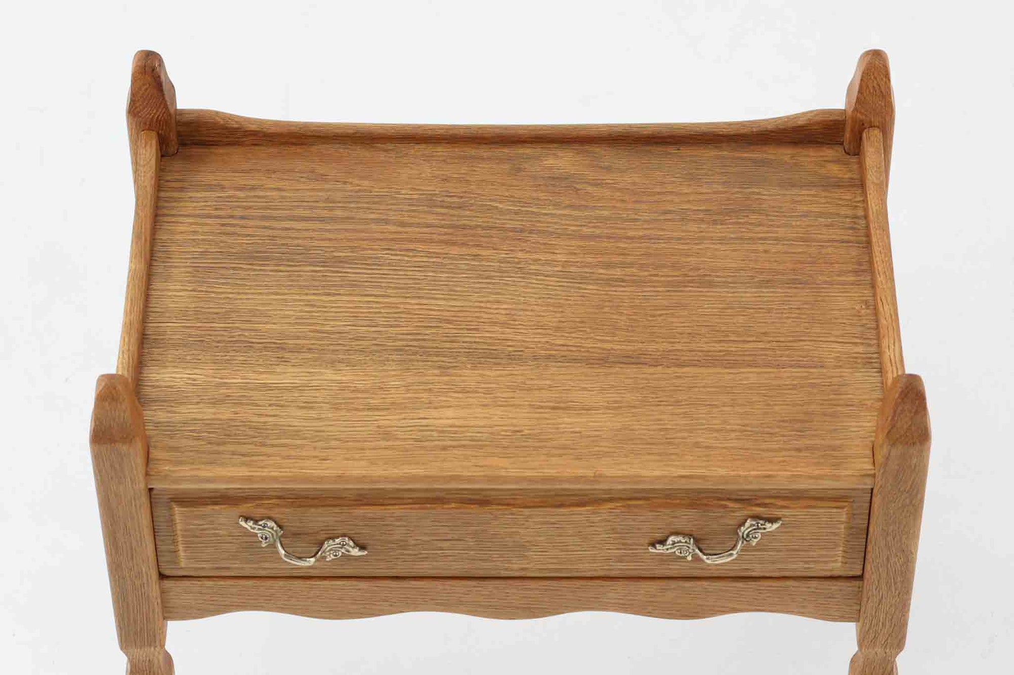 デンマークのデザイナー、Henning Kjaernulfによってデザインされたヴィンテージのサイドチェスト。素材には、木目の美しいオーク材が用いられており、しっかりとした存在感と温かみを感じさせます。脚部や幕板には柔らかな曲線が施され、ケアヌルフらしい彫刻的なフォルムが印象的。天板の縁や引き出しの装飾的なハンドルにもクラフトマンシップが光ります。引き出し1杯のシンプルな構造ながら、細部にこだわった造形が空間に個性を添える一台。ベッドサイドはもちろん、玄関先やリビングにもおすすめのアイテムです。※背面が前オーナーにより一部カットされているため、価格に反映しております。