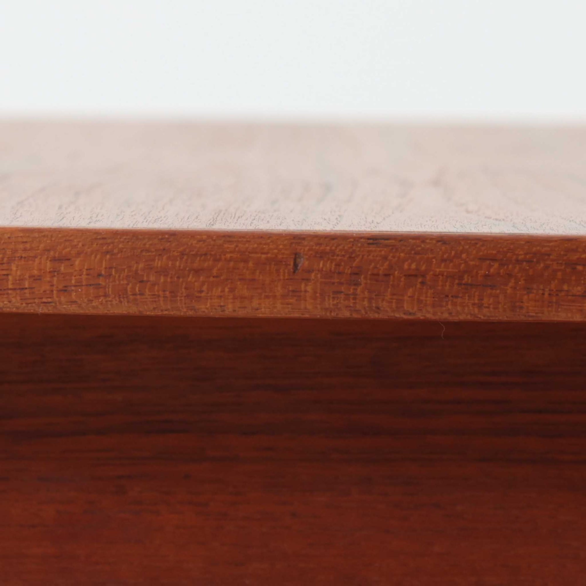 チーク材を用いたこちらの2段チェストは、緩やかにカーブした天板と舟形の引き手が特徴的な北欧ビンテージ家具です。幅64cmとコンパクトながらも引き出し2杯と下部の棚板を備え、収納力とディスプレイ性を兼ね備えています。テーパー脚が軽やかな印象を与え、ベッドサイドやリビングのサイドテーブルとしても活躍。年月を経た木肌の温かみが、空間に落ち着きと味わい深い存在感をもたらす一品です。