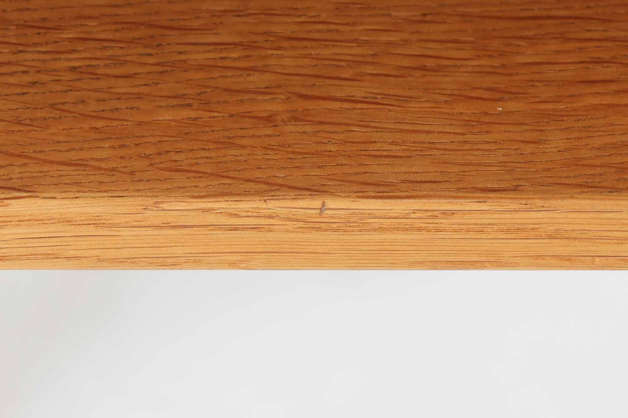 デンマークを代表する家具デザイナー、Hans J. Wegner（ハンス・J・ウェグナー）によってデザインされた、Ry mobler社製のビンテージサイドテーブルです。素材にはあたたかみのあるオーク材が用いられており、北欧らしいシンプルかつ機能的な美しさが感じられます。天板は縁に立ち上がりがあり、物が転がり落ちにくい仕様。引き出しとオープンスペースが組み合わされた実用的な構造で、ベッドサイドやソファ横、玄関周りなど様々なシーンで活躍します。無駄のないデザインと丸脚の柔らかな佇まいが魅力で、ウェグナーデザインならではのバランス感が光る一台です。