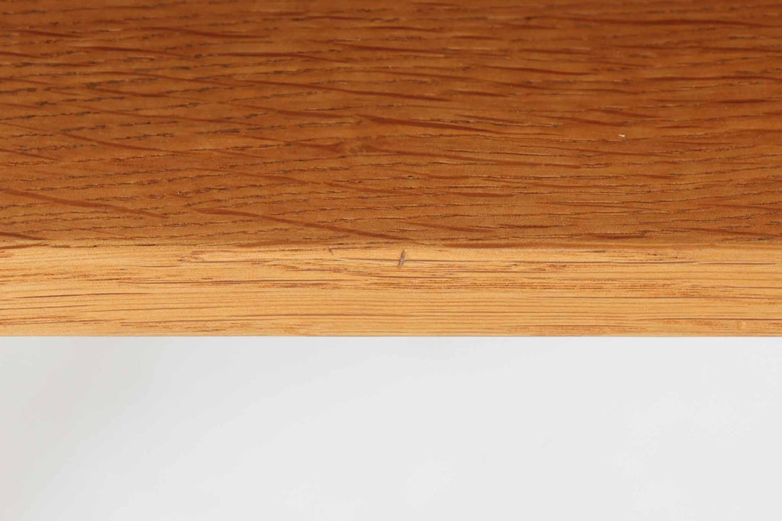 デンマークを代表する家具デザイナー、Hans J. Wegner（ハンス・J・ウェグナー）によってデザインされた、Ry mobler社製のビンテージサイドテーブルです。素材にはあたたかみのあるオーク材が用いられており、北欧らしいシンプルかつ機能的な美しさが感じられます。天板は縁に立ち上がりがあり、物が転がり落ちにくい仕様。引き出しとオープンスペースが組み合わされた実用的な構造で、ベッドサイドやソファ横、玄関周りなど様々なシーンで活躍します。無駄のないデザインと丸脚の柔らかな佇まいが魅力で、ウェグナーデザインならではのバランス感が光る一台です。