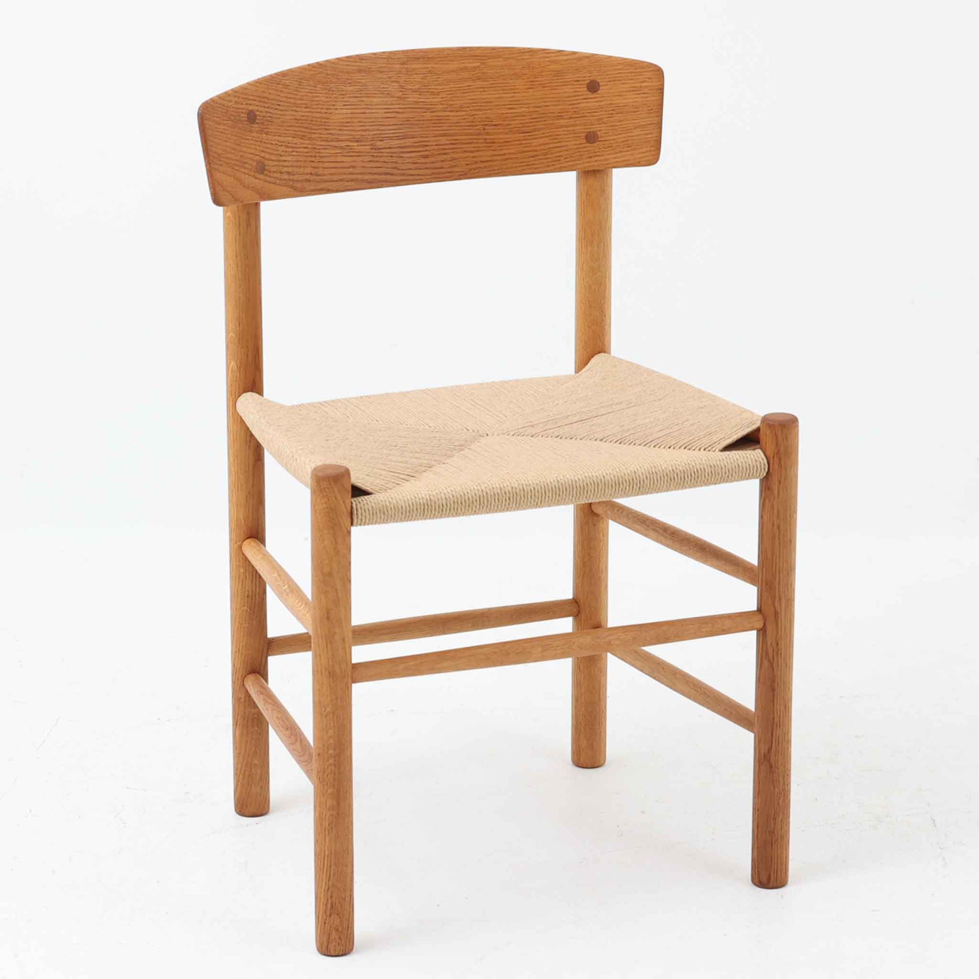 デンマークを代表するデザイナー、Borge MogensenによってFDBのためにデザインされたJ39チェアは、オーク材の丸脚と座面に丁寧に編み込まれたペーパーコードが特徴の、素朴ながらも完成度の高い北欧ビンテージチェアです。農村のキッチンチェアをルーツに持つそのデザインは、無駄を省いた潔い構造と機能美が融合し、空間に凛とした佇まいをもたらします。ダイニングはもちろん、ワークチェアやアクセントチェアとしても重宝する一脚です。