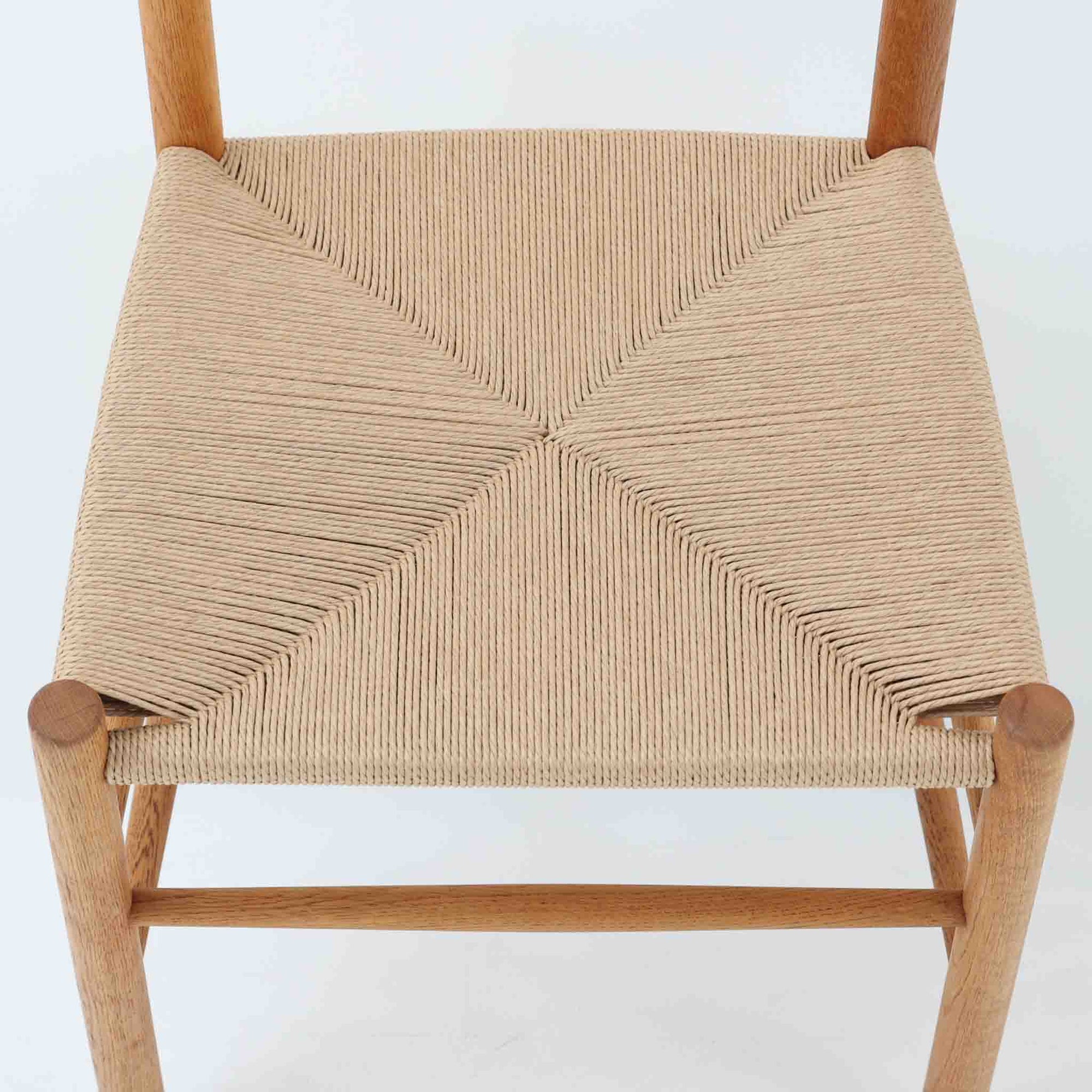 デンマークを代表するデザイナー、Borge MogensenによってFDBのためにデザインされたJ39チェアは、オーク材の丸脚と座面に丁寧に編み込まれたペーパーコードが特徴の、素朴ながらも完成度の高い北欧ビンテージチェアです。農村のキッチンチェアをルーツに持つそのデザインは、無駄を省いた潔い構造と機能美が融合し、空間に凛とした佇まいをもたらします。ダイニングはもちろん、ワークチェアやアクセントチェアとしても重宝する一脚です。