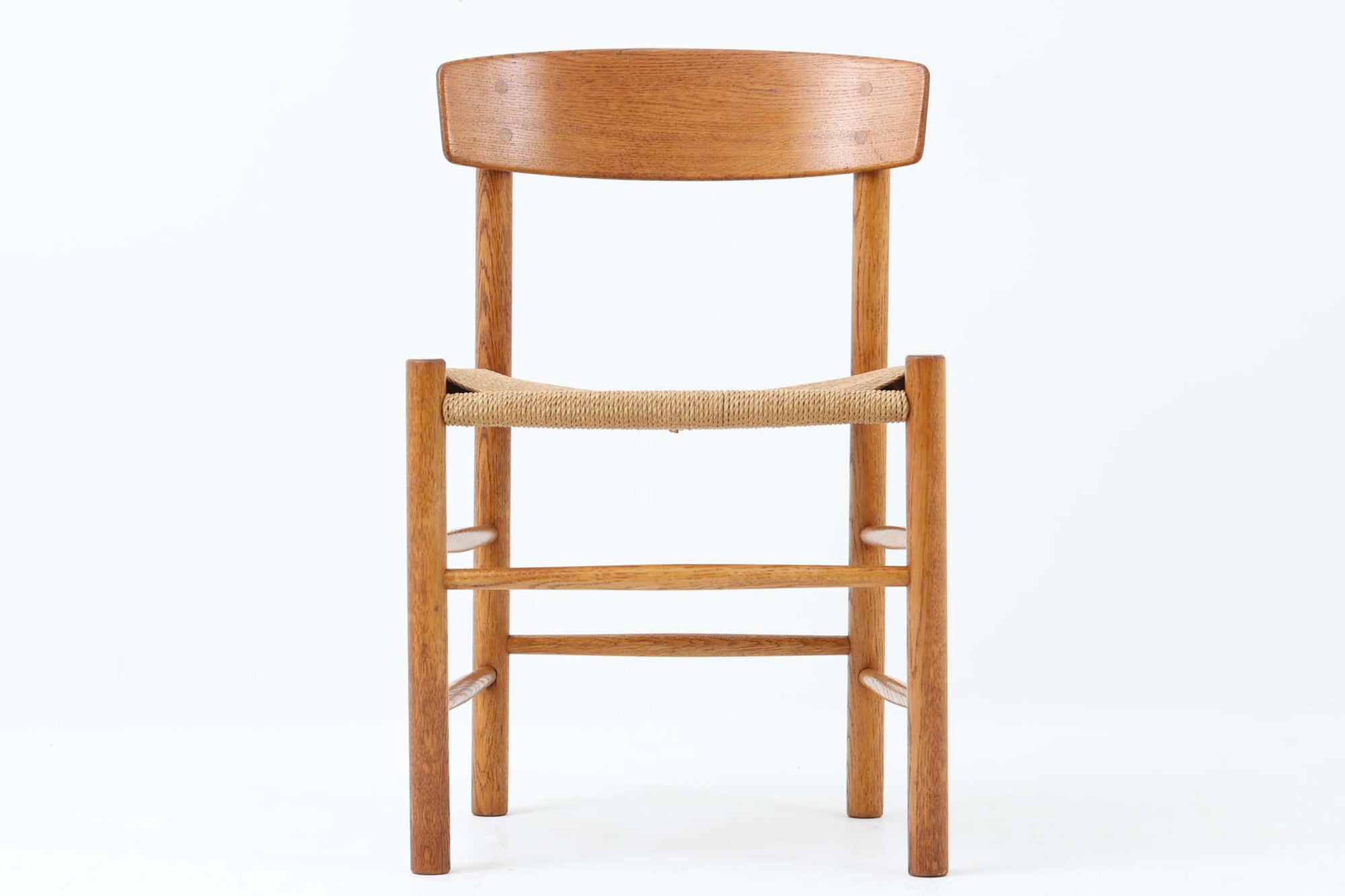 こちらは、1956年にデザインされたJ39チェアです。そのシンプルで頑丈なデザインは広く知られ、「The People's Chair（人々の椅子）」としても愛されています。現在はFredericia社から販売されていますが、こちらは初期のFDB mobler社製の貴重なモデルです。クリーニングのみ行った状態で、経年により色味が深みを増したオーク材のフレームが魅力的です。ビンテージ感をお楽しみいただける状態でお手頃価格でご提供しています。