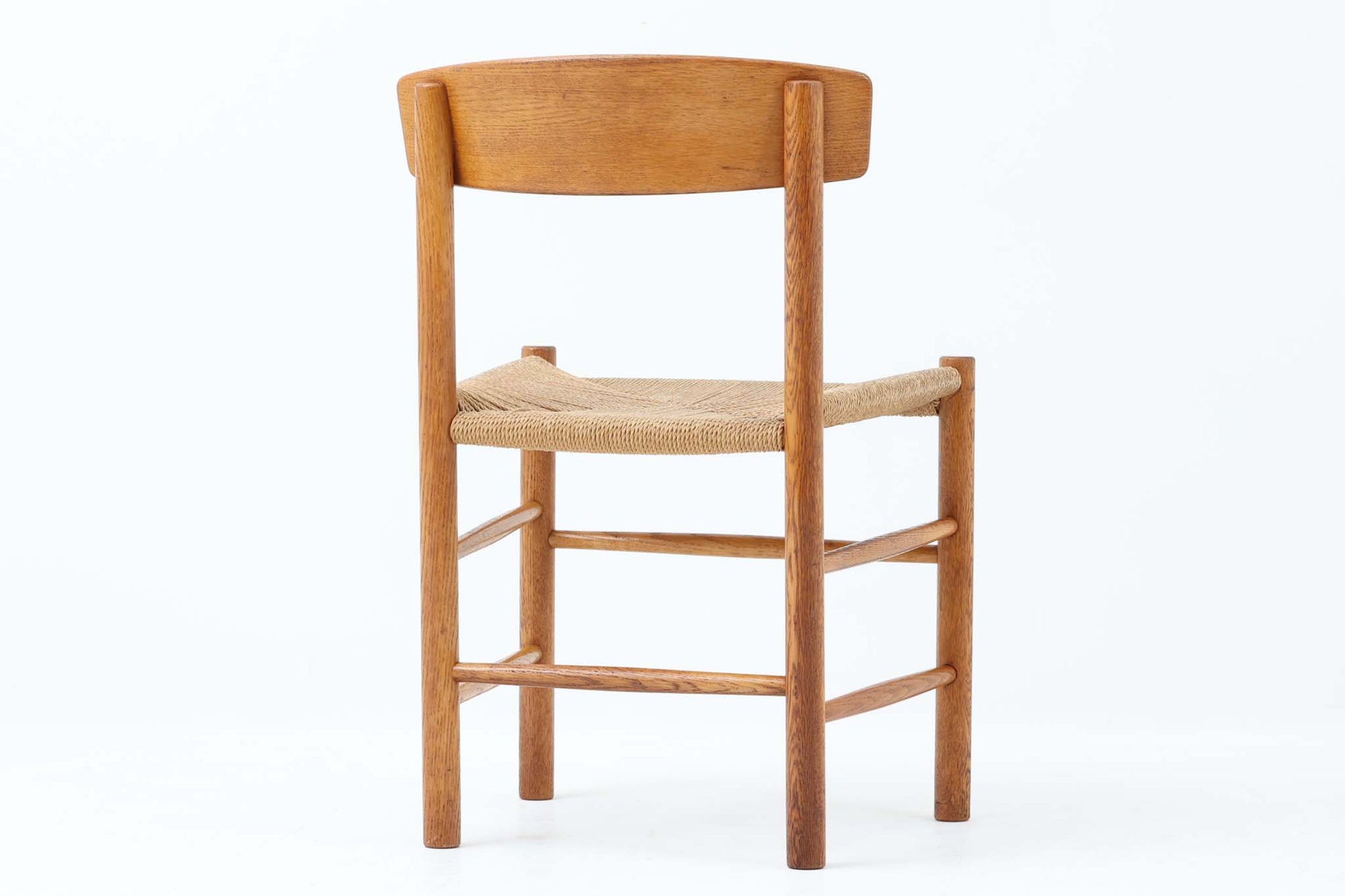 こちらは、1956年にデザインされたJ39チェアです。そのシンプルで頑丈なデザインは広く知られ、「The People's Chair（人々の椅子）」としても愛されています。現在はFredericia社から販売されていますが、こちらは初期のFDB mobler社製の貴重なモデルです。クリーニングのみ行った状態で、経年により色味が深みを増したオーク材のフレームが魅力的です。ビンテージ感をお楽しみいただける状態でお手頃価格でご提供しています。