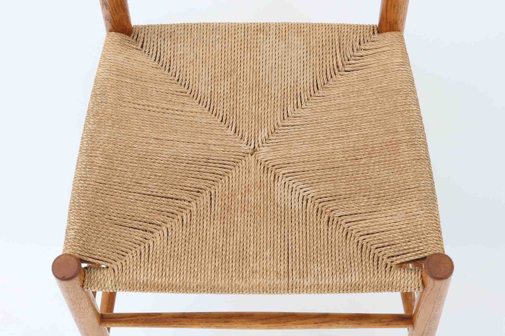 こちらは、1956年にデザインされたJ39チェアです。そのシンプルで頑丈なデザインは広く知られ、「The People's Chair（人々の椅子）」としても愛されています。現在はFredericia社から販売されていますが、こちらは初期のFDB mobler社製の貴重なモデルです。クリーニングのみ行った状態で、経年により色味が深みを増したオーク材のフレームが魅力的です。ビンテージ感をお楽しみいただける状態でお手頃価格でご提供しています。