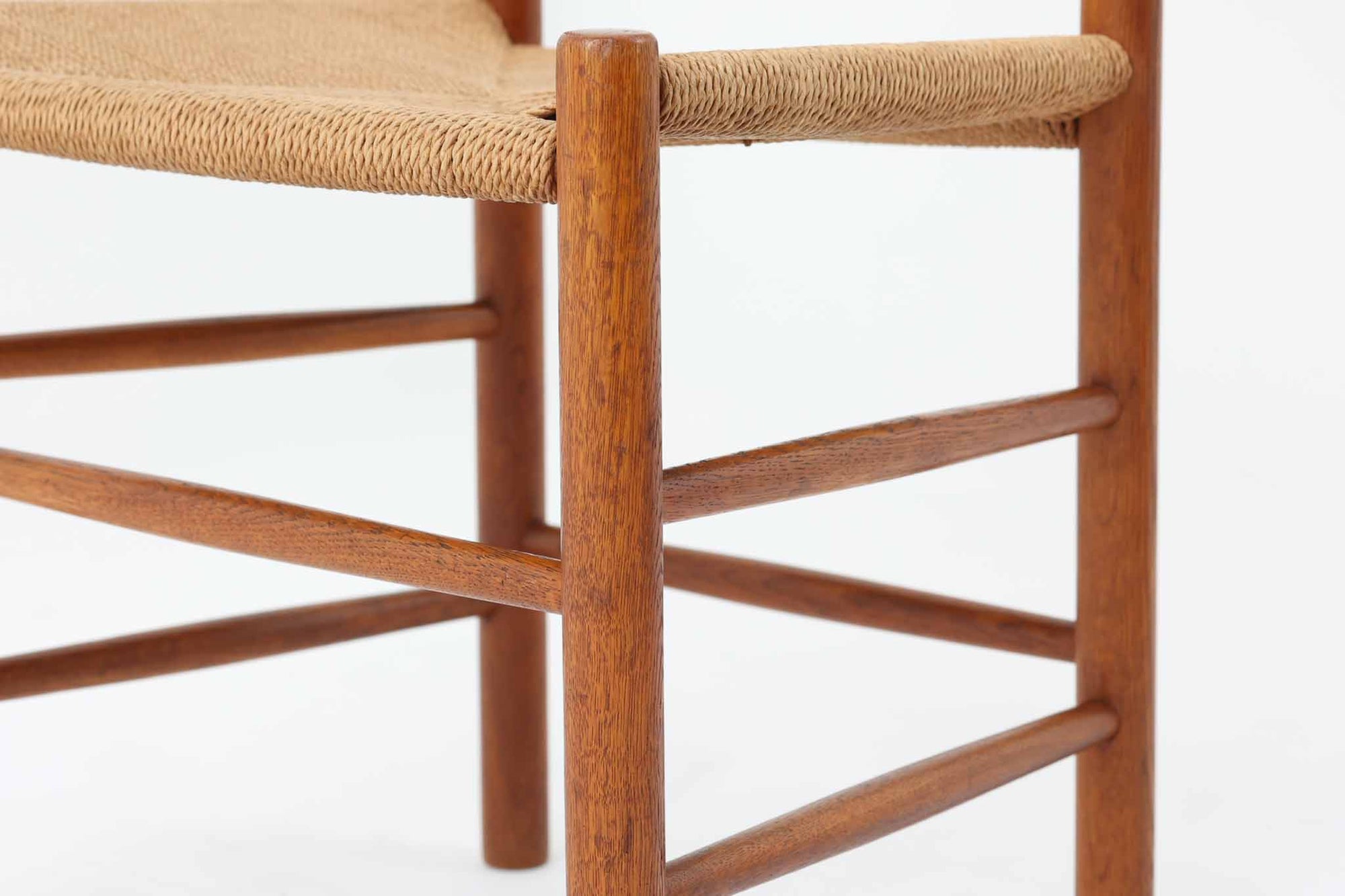 こちらは、1956年にデザインされたJ39チェアです。そのシンプルで頑丈なデザインは広く知られ、「The People's Chair（人々の椅子）」としても愛されています。現在はFredericia社から販売されていますが、こちらは初期のFDB mobler社製の貴重なモデルです。クリーニングのみ行った状態で、経年により色味が深みを増したオーク材のフレームが魅力的です。ビンテージ感をお楽しみいただける状態でお手頃価格でご提供しています。