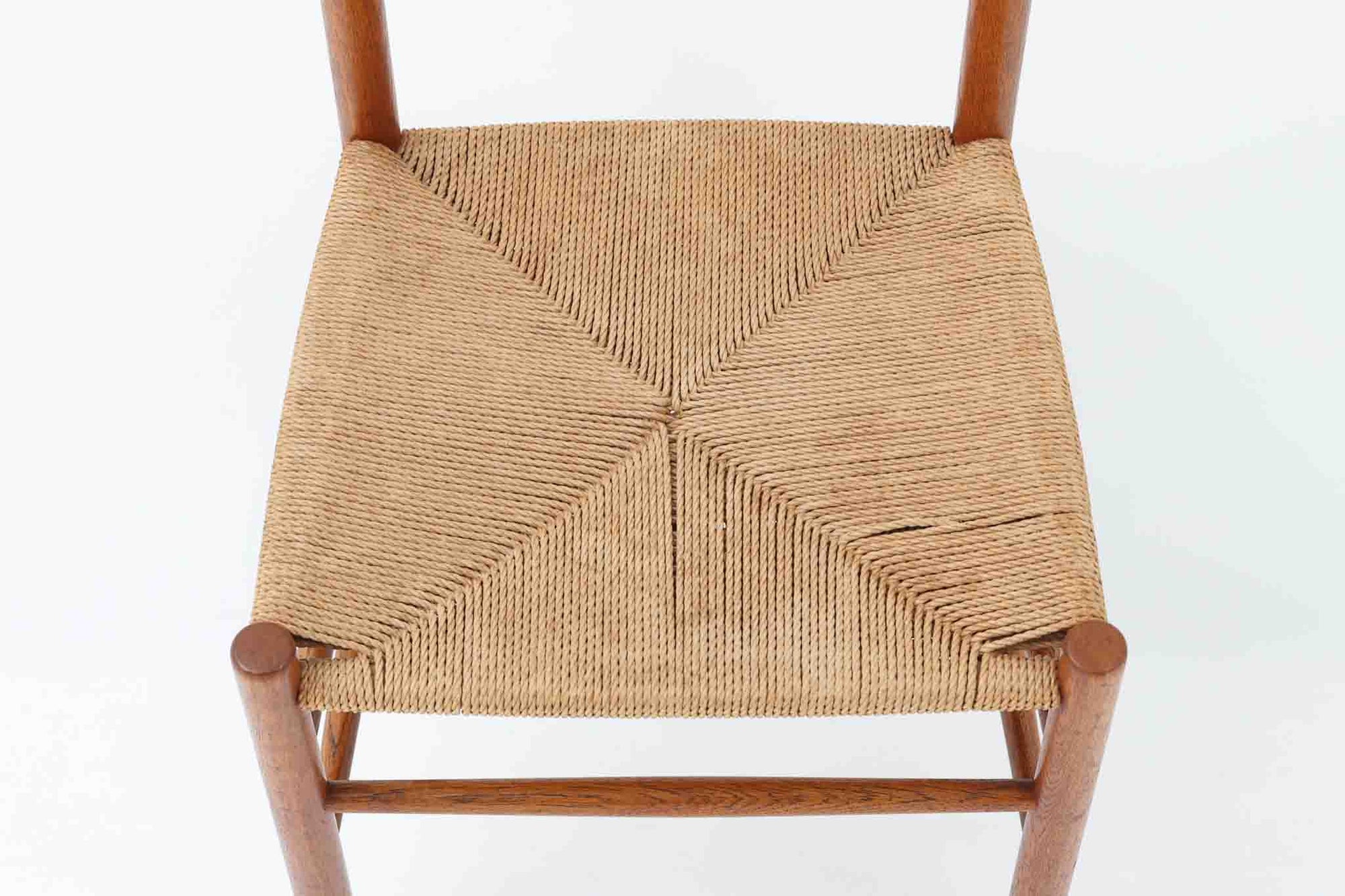 こちらは、1956年にデザインされたJ39チェアです。そのシンプルで頑丈なデザインは広く知られ、「The People's Chair（人々の椅子）」としても愛されています。現在はFredericia社から販売されていますが、こちらは初期のFDB mobler社製の貴重なモデルです。クリーニングのみ行った状態で、経年により色味が深みを増したオーク材のフレームが魅力的です。ビンテージ感をお楽しみいただける状態でお手頃価格でご提供しています。