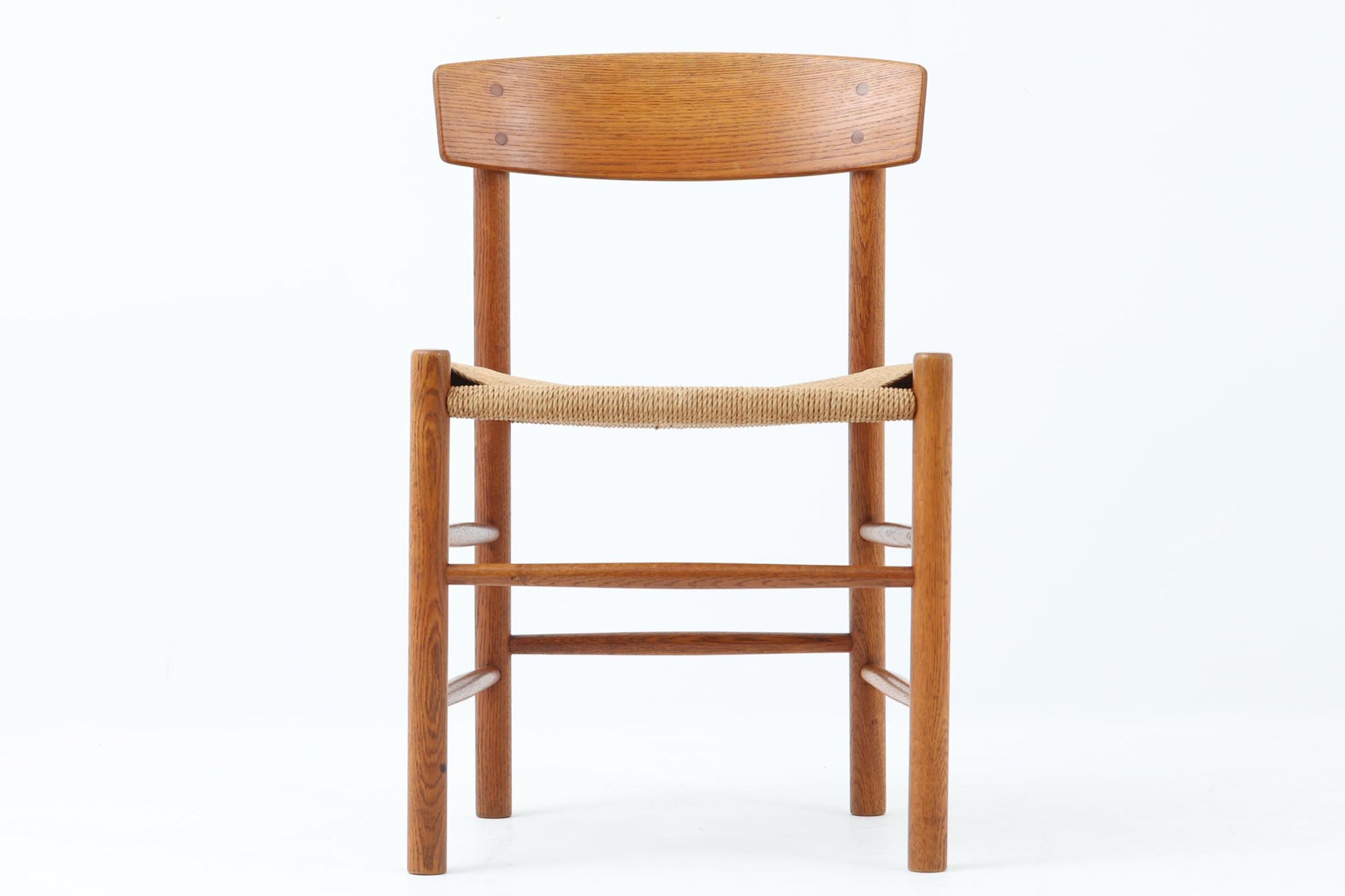 こちらは、1956年にデザインされたJ39チェアです。そのシンプルで頑丈なデザインは広く知られ、「The People's Chair（人々の椅子）」としても愛されています。現在はFredericia社から販売されていますが、こちらは初期のFDB mobler社製の貴重なモデルです。クリーニングのみ行った状態で、経年により色味が深みを増したオーク材のフレームが魅力的です。ビンテージ感をお楽しみいただける状態でお手頃価格でご提供しています。