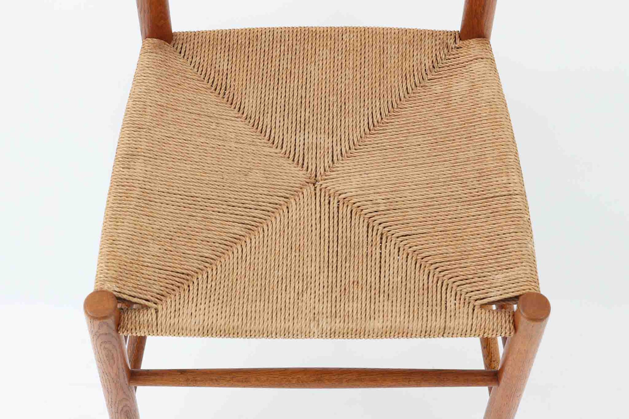 こちらは、1956年にデザインされたJ39チェアです。そのシンプルで頑丈なデザインは広く知られ、「The People's Chair（人々の椅子）」としても愛されています。現在はFredericia社から販売されていますが、こちらは初期のFDB mobler社製の貴重なモデルです。クリーニングのみ行った状態で、経年により色味が深みを増したオーク材のフレームが魅力的です。ビンテージ感をお楽しみいただける状態でお手頃価格でご提供しています。