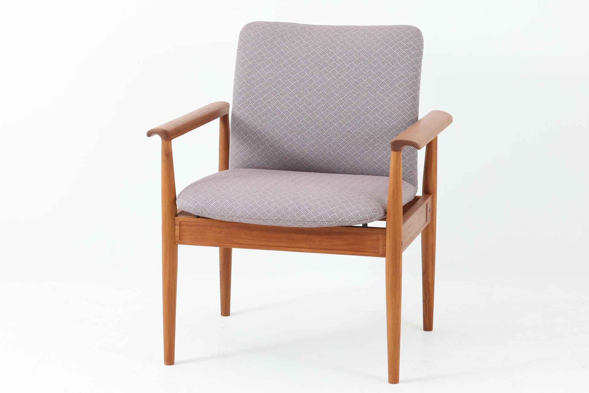 デンマークの名門France & Son社製、Finn Juhl（フィン・ユール）による名作「Diplomat Chair」です。Diplomat（外交官）チェアの名にふさわしく、洗練された造形と座り心地が魅力の一脚。本体には美しい木目のチーク材が使用され、肘掛けのカーブや脚部の細やかな造形からはJuhlらしい彫刻的な美意識が感じられます。France & Son社のオリジナルロゴプレートも残っており、コレクターズアイテムとしても価値の高い逸品です。
