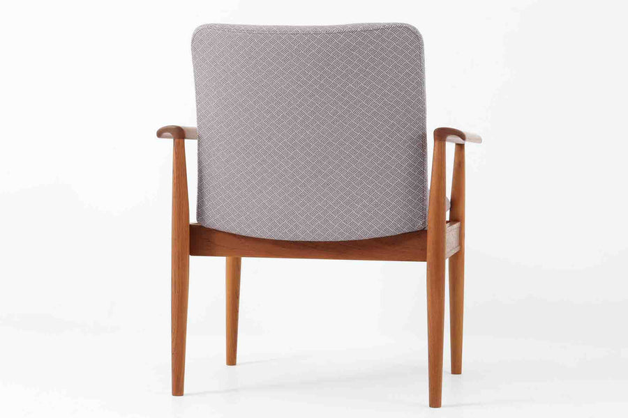 デンマークの名門France & Son社製、Finn Juhl（フィン・ユール）による名作「Diplomat Chair」です。Diplomat（外交官）チェアの名にふさわしく、洗練された造形と座り心地が魅力の一脚。本体には美しい木目のチーク材が使用され、肘掛けのカーブや脚部の細やかな造形からはJuhlらしい彫刻的な美意識が感じられます。France & Son社のオリジナルロゴプレートも残っており、コレクターズアイテムとしても価値の高い逸品です。
