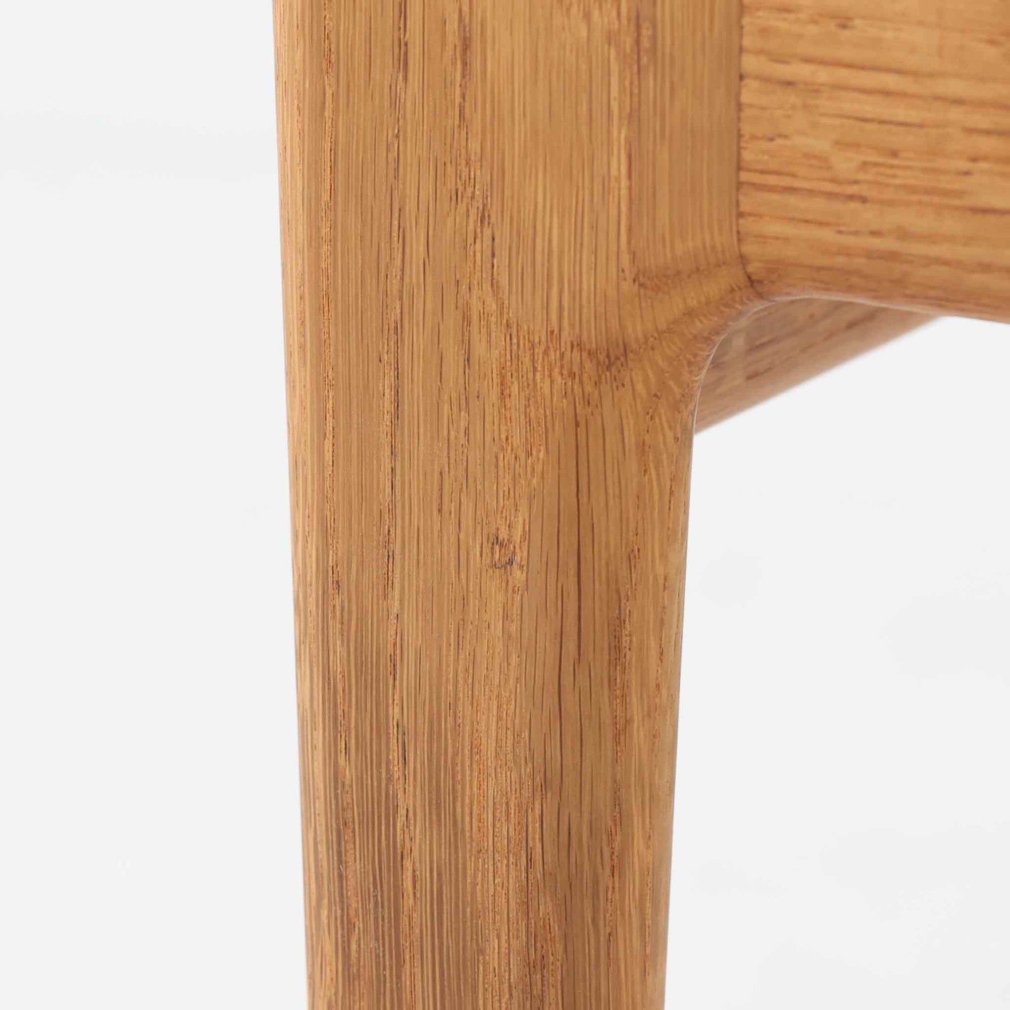 Hans J. WegnerがデザインしGetama社から発表されたGE290オットマンは、堅牢なオーク材のフレームと深みのあるブルーの張地が美しく調和した北欧ビンテージ家具です。直線的でありながら丸みを帯びた脚部が軽快な印象を与え、ソファと組み合わせてフットレストとしてはもちろん、単体でも腰掛けとして使用できます。経年による木肌の風合いと上質な張地が落ち着いた存在感を放つ逸品です。