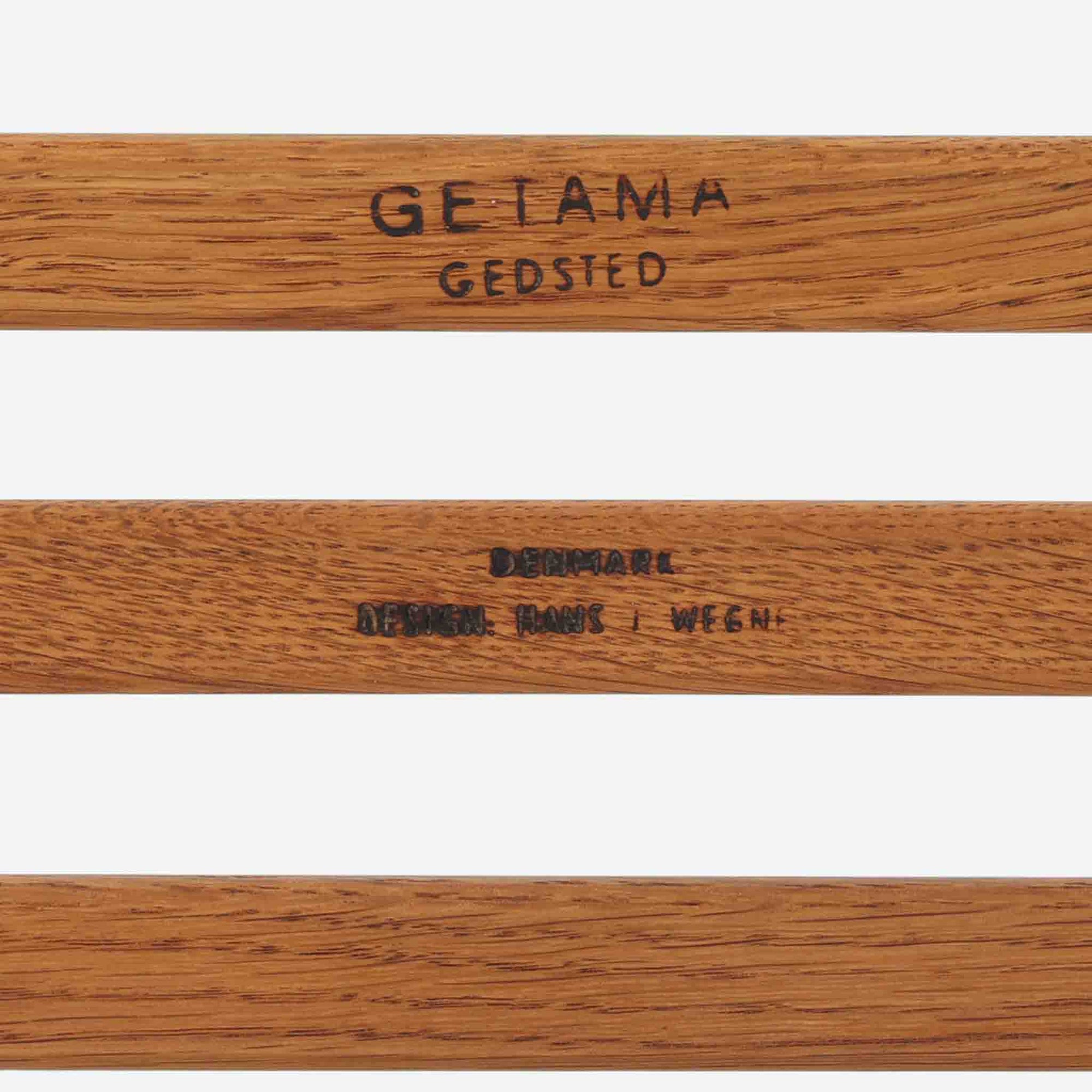 Hans J. WegnerがデザインしGetama社から発表されたGE290オットマンは、堅牢なオーク材のフレームと深みのあるブルーの張地が美しく調和した北欧ビンテージ家具です。直線的でありながら丸みを帯びた脚部が軽快な印象を与え、ソファと組み合わせてフットレストとしてはもちろん、単体でも腰掛けとして使用できます。経年による木肌の風合いと上質な張地が落ち着いた存在感を放つ逸品です。