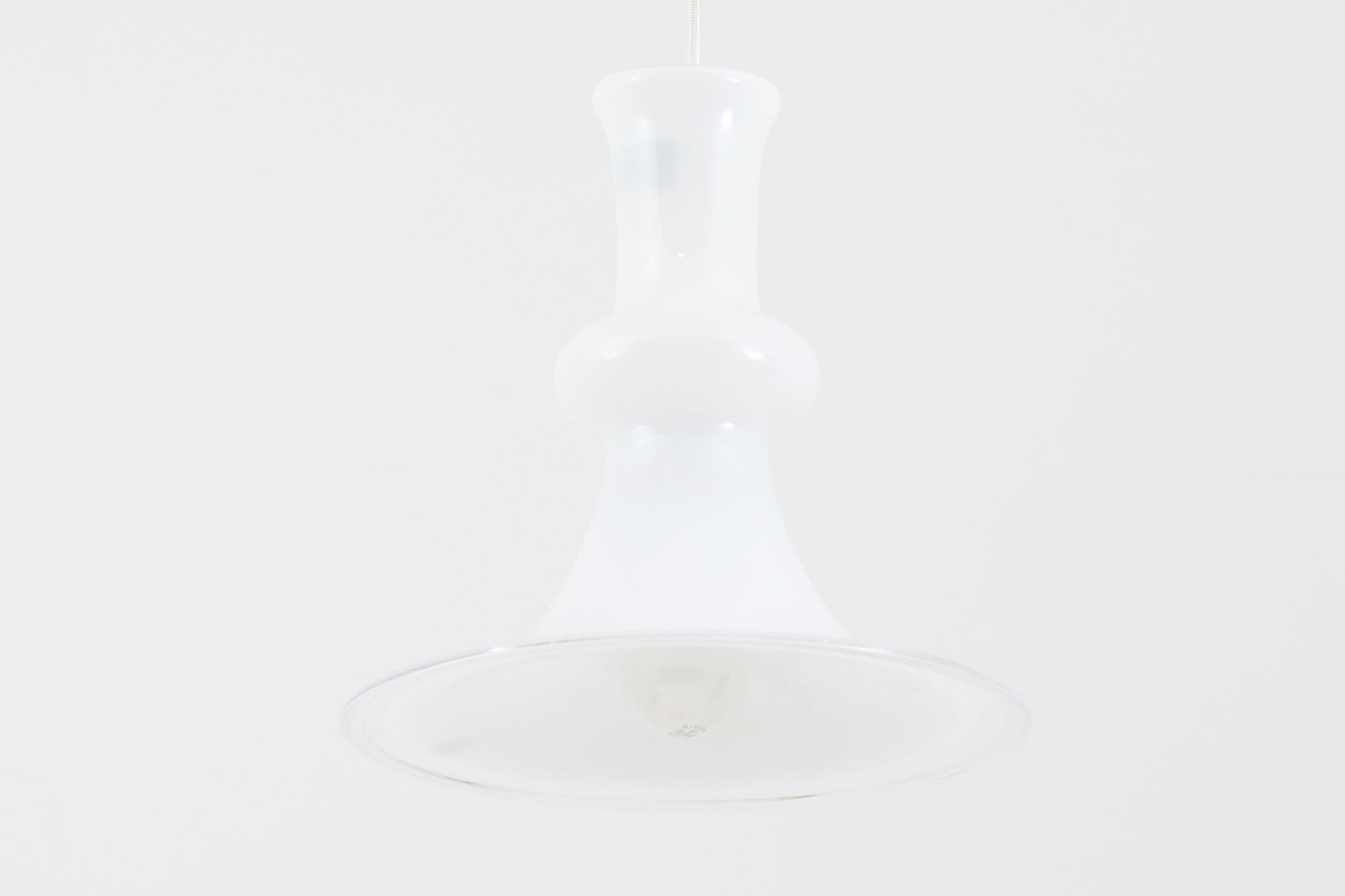 北欧より買い付けた、ホルムガード社製(現Royal Copenhagen)ビンテージランプです。ガラス製のペンダントライト「Etude Pendel」。クラシカルな曲線が美しいフォルムと、乳白色のガラスシェードが柔らかな光を拡げ、空間に優しい印象を与えてくれます。シェード下部はクリアガラスになっており、下方向への光をしっかり届けながらも、グラデーションのような光の演出が楽しめます。直径約28cmと使いやすいサイズで、ダイニングや玄関、ベッドサイドなど多様なシーンで活躍します。エレガントで品のある北欧照明をお探しの方におすすめの一灯です。