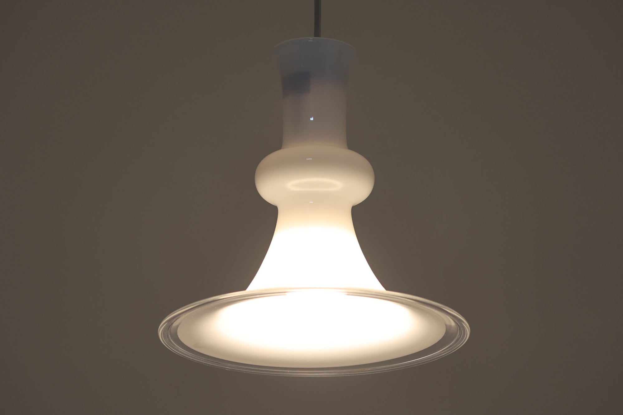 北欧より買い付けた、ホルムガード社製(現Royal Copenhagen)ビンテージランプです。ガラス製のペンダントライト「Etude Pendel」。クラシカルな曲線が美しいフォルムと、乳白色のガラスシェードが柔らかな光を拡げ、空間に優しい印象を与えてくれます。シェード下部はクリアガラスになっており、下方向への光をしっかり届けながらも、グラデーションのような光の演出が楽しめます。直径約28cmと使いやすいサイズで、ダイニングや玄関、ベッドサイドなど多様なシーンで活躍します。エレガントで品のある北欧照明をお探しの方におすすめの一灯です。