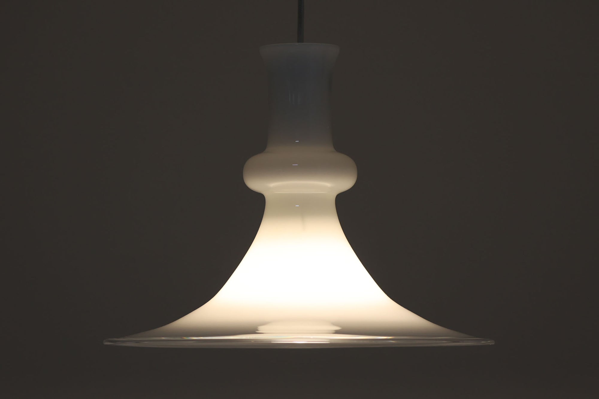 北欧より買い付けた、ホルムガード社製(現Royal Copenhagen)ビンテージランプです。ガラス製のペンダントライト「Etude Pendel」。パールホワイトのガラスとクリアエッジの組み合わせにより、灯りを点けると柔らかく温かみのある光が広がり、空間にやさしい印象をもたらします。シェード外周に細かい擦れや製造時の練りムラなど見られますが、全体としてはビンテージ品として良好なコンディションです。ソケット内部には「ROYAL COPENHAGEN TYPE: ETUDE PENDEL」の表記あり。北欧モダンを象徴する美しい照明です。