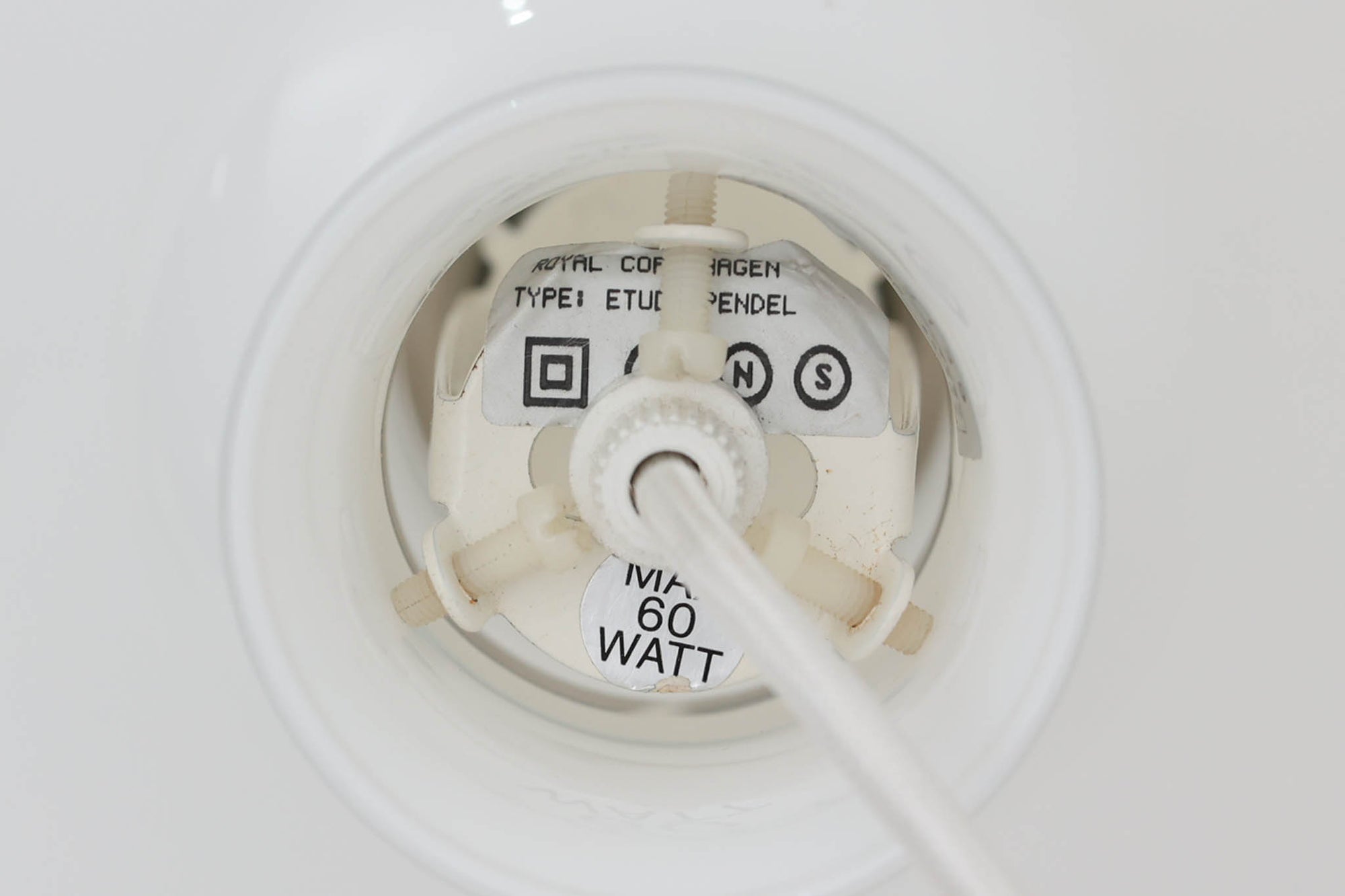 北欧より買い付けた、ホルムガード社製(現Royal Copenhagen)ビンテージランプです。ガラス製のペンダントライト「Etude Pendel」。パールホワイトのガラスとクリアエッジの組み合わせにより、灯りを点けると柔らかく温かみのある光が広がり、空間にやさしい印象をもたらします。シェード外周に細かい擦れや製造時の練りムラなど見られますが、全体としてはビンテージ品として良好なコンディションです。ソケット内部には「ROYAL COPENHAGEN TYPE: ETUDE PENDEL」の表記あり。北欧モダンを象徴する美しい照明です。