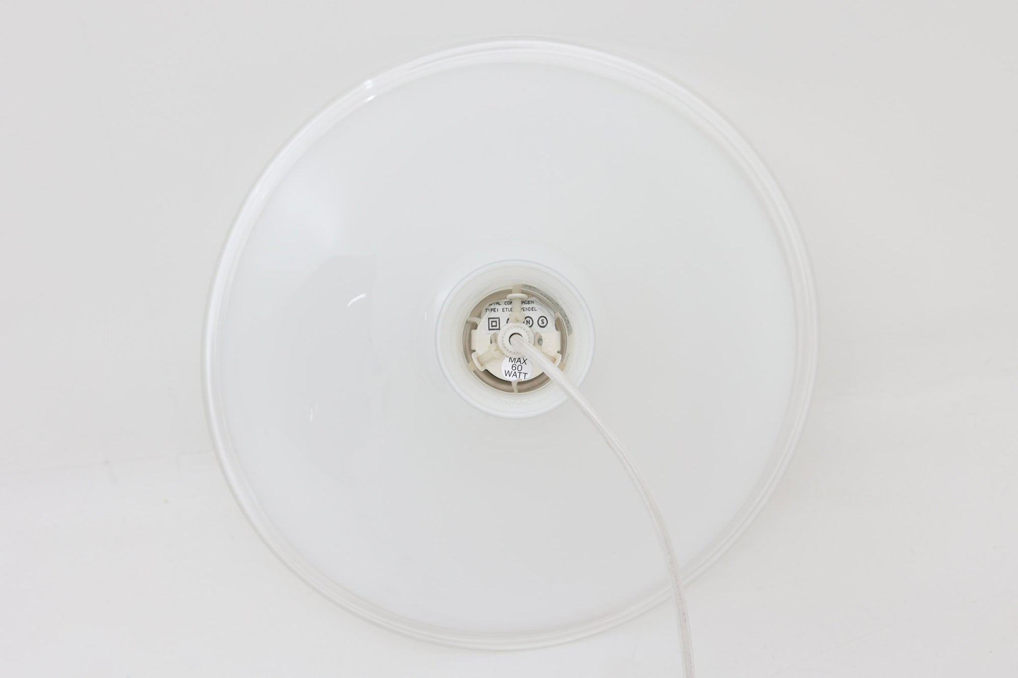 北欧より買い付けた、ホルムガード社製(現Royal Copenhagen)ビンテージランプです。ガラス製のペンダントライト「Etude Pendel」。パールホワイトのガラスとクリアエッジの組み合わせにより、灯りを点けると柔らかく温かみのある光が広がり、空間にやさしい印象をもたらします。シェード外周に細かい擦れや製造時の練りムラなど見られますが、全体としてはビンテージ品として良好なコンディションです。ソケット内部には「ROYAL COPENHAGEN TYPE: ETUDE PENDEL」の表記あり。北欧モダンを象徴する美しい照明です。