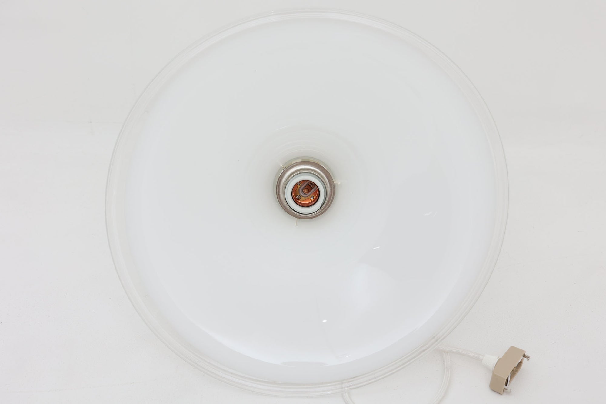 北欧より買い付けた、ホルムガード社製(現Royal Copenhagen)ビンテージランプです。ガラス製のペンダントライト「Etude Pendel」。パールホワイトのガラスとクリアエッジの組み合わせにより、灯りを点けると柔らかく温かみのある光が広がり、空間にやさしい印象をもたらします。シェード外周に細かい擦れや製造時の練りムラなど見られますが、全体としてはビンテージ品として良好なコンディションです。ソケット内部には「ROYAL COPENHAGEN TYPE: ETUDE PENDEL」の表記あり。北欧モダンを象徴する美しい照明です。