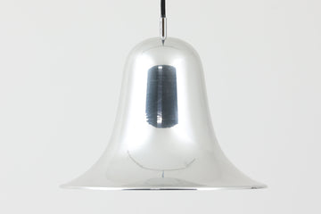 デンマークを代表する照明デザイナーVerner Panton（バーナー・パントン）が手がけた、Frandsen Lighting（フランセン・ライティング）社製のペンダントライトです。なだらかな曲線を描くベル型のシルエットに、ミラーのように周囲を映し出すクローム仕上げが施された、存在感のある一灯。直径約30cmと比較的大ぶりなサイズ感で、1灯でも空間のアクセントとなり、テーブル上や吹き抜け空間などにも映えます。内側はホワイトに塗装されており、点灯時には光を柔らかく広げながらもしっかりとした明るさを確保。Frandsen Lighting社はかつてVerner Pantonとのライセンス契約を結び、このモデルを製造していましたが、現在ではその契約も終了しており、本品のようなオリジナルはヴィンテージ品でしか手に入らなくなっています。特に直径30cmの大きなサイズは現行品では展開されておらず、希少性の高いアイテムとなっています。