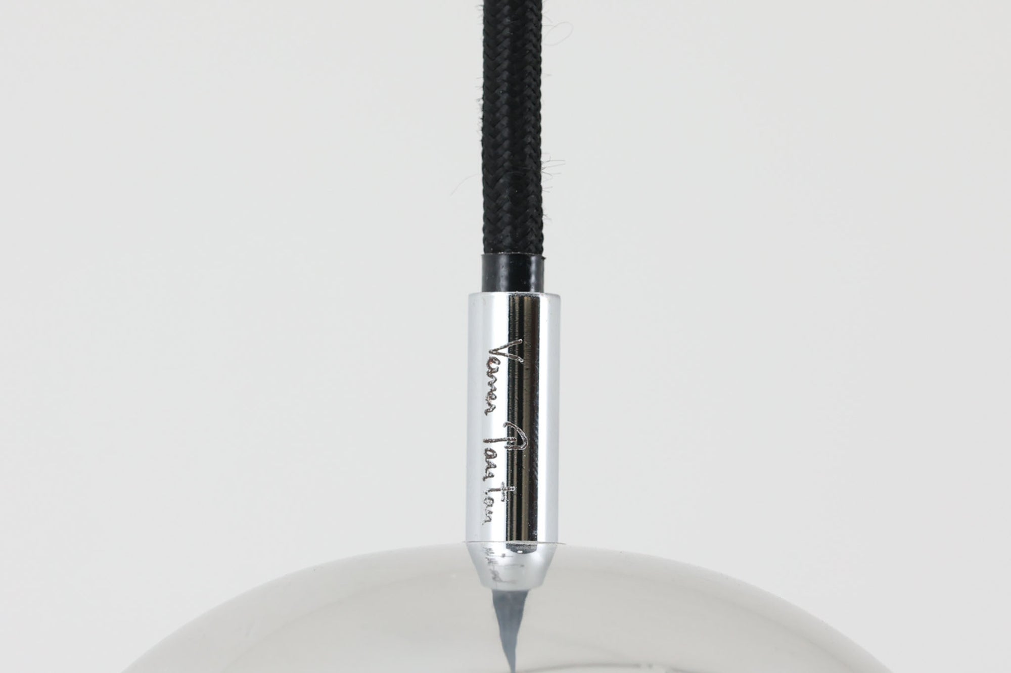 デンマークを代表する照明デザイナーVerner Panton（バーナー・パントン）が手がけた、Frandsen Lighting（フランセン・ライティング）社製のペンダントライトです。なだらかな曲線を描くベル型のシルエットに、ミラーのように周囲を映し出すクローム仕上げが施された、存在感のある一灯。直径約30cmと比較的大ぶりなサイズ感で、1灯でも空間のアクセントとなり、テーブル上や吹き抜け空間などにも映えます。内側はホワイトに塗装されており、点灯時には光を柔らかく広げながらもしっかりとした明るさを確保。Frandsen Lighting社はかつてVerner Pantonとのライセンス契約を結び、このモデルを製造していましたが、現在ではその契約も終了しており、本品のようなオリジナルはヴィンテージ品でしか手に入らなくなっています。特に直径30cmの大きなサイズは現行品では展開されておらず、希少性の高いアイテムとなっています。