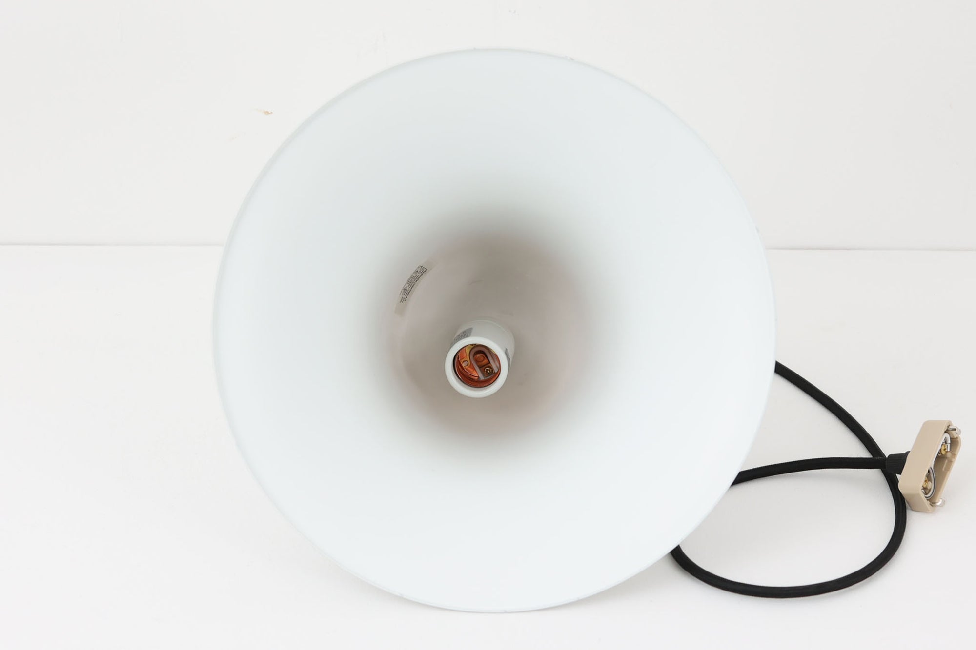 デンマークを代表する照明デザイナーVerner Panton（バーナー・パントン）が手がけた、Frandsen Lighting（フランセン・ライティング）社製のペンダントライトです。なだらかな曲線を描くベル型のシルエットに、ミラーのように周囲を映し出すクローム仕上げが施された、存在感のある一灯。直径約30cmと比較的大ぶりなサイズ感で、1灯でも空間のアクセントとなり、テーブル上や吹き抜け空間などにも映えます。内側はホワイトに塗装されており、点灯時には光を柔らかく広げながらもしっかりとした明るさを確保。Frandsen Lighting社はかつてVerner Pantonとのライセンス契約を結び、このモデルを製造していましたが、現在ではその契約も終了しており、本品のようなオリジナルはヴィンテージ品でしか手に入らなくなっています。特に直径30cmの大きなサイズは現行品では展開されておらず、希少性の高いアイテムとなっています。