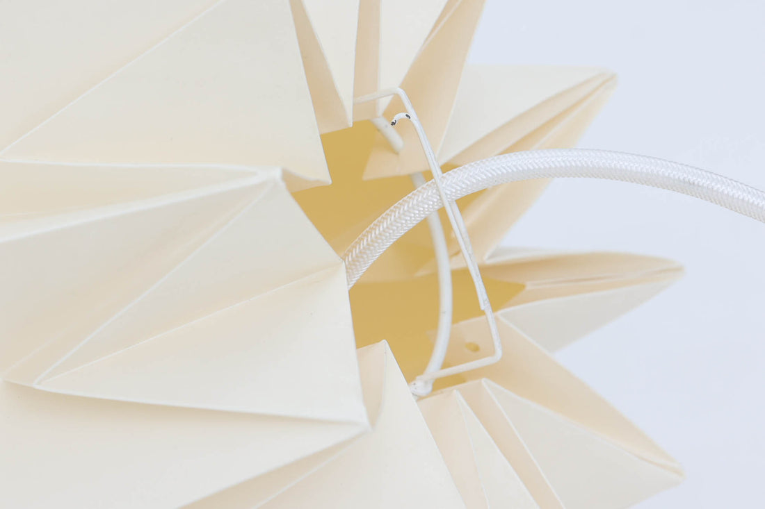 デンマークの名門Le Klintによるmodel 152。Peter Hvidt & Orla mølgaard Nielsenによってデザインされたこのモデルは、手折りのプリーツシェードによって生まれる立体的な陰影が魅力。点灯時には柔らかく温かみのある光を放ち、消灯時もアートピースのような存在感を放ちます。シェードには経年による軽微な変色や小さな折れが見られますが、全体として美しいフォルムと機能性を兼ね備えています。直径約27cmで、玄関やダイニング、ベッドサイドにもおすすめのサイズです。