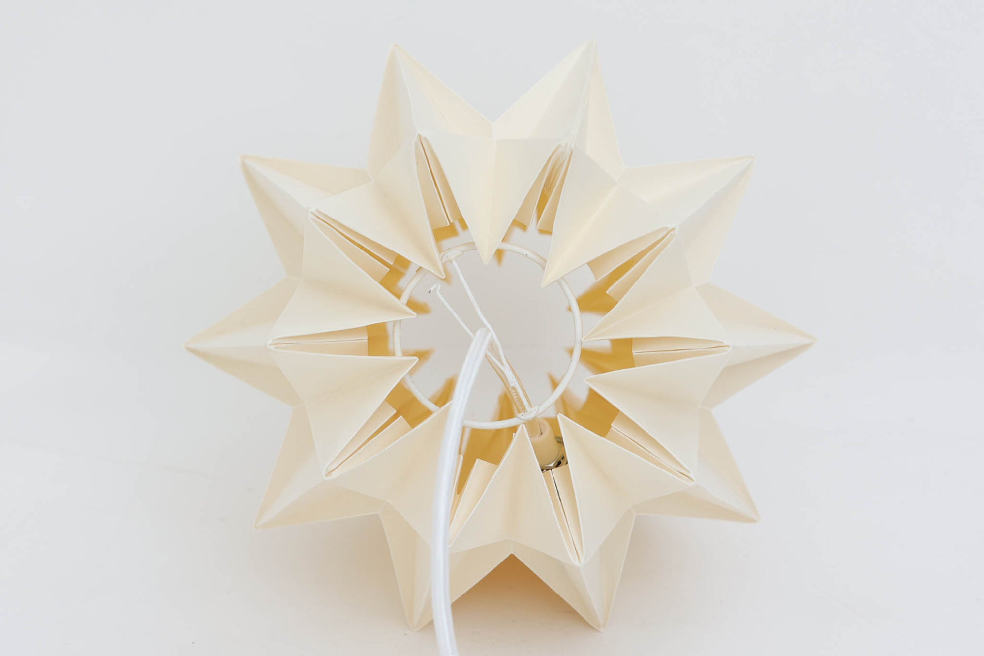 デンマークの名門Le Klintによるmodel 152。Peter Hvidt &amp; Orla mølgaard Nielsenによってデザインされたこのモデルは、手折りのプリーツシェードによって生まれる立体的な陰影が魅力。点灯時には柔らかく温かみのある光を放ち、消灯時もアートピースのような存在感を放ちます。シェードには経年による軽微な変色や小さな折れが見られますが、全体として美しいフォルムと機能性を兼ね備えています。直径約27cmで、玄関やダイニング、ベッドサイドにもおすすめのサイズです。