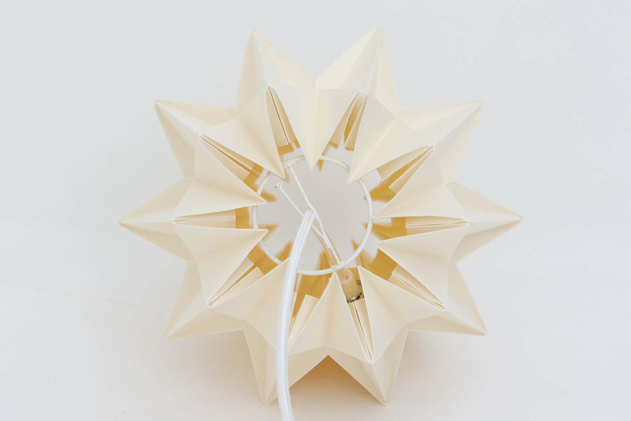 デンマークの名門Le Klintによるmodel 152。Peter Hvidt & Orla mølgaard Nielsenによってデザインされたこのモデルは、手折りのプリーツシェードによって生まれる立体的な陰影が魅力。点灯時には柔らかく温かみのある光を放ち、消灯時もアートピースのような存在感を放ちます。シェードには経年による軽微な変色や小さな折れが見られますが、全体として美しいフォルムと機能性を兼ね備えています。直径約27cmで、玄関やダイニング、ベッドサイドにもおすすめのサイズです。