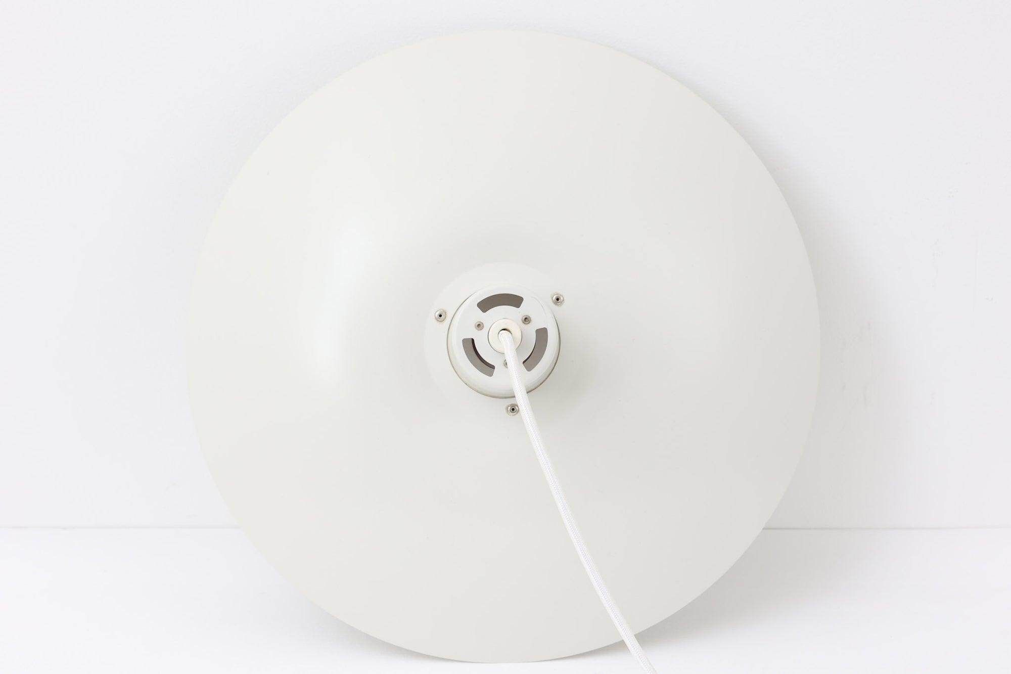 北欧照明の巨匠Poul Henningsenによってデザインされた「PH4」ペンダントライト。Louis Poulsen社製で、光を効率よく拡散させる3枚シェード構造が特徴。内側にオレンジのリフレクターを備えており、暖かく落ち着いた光を演出します。シェード表面には経年に伴う擦れや細かい傷、塗装の薄れが見られますが、ビンテージらしい味わいを感じられる一品です。リビングやダイニング、カウンター上などにおすすめのサイズ感です。