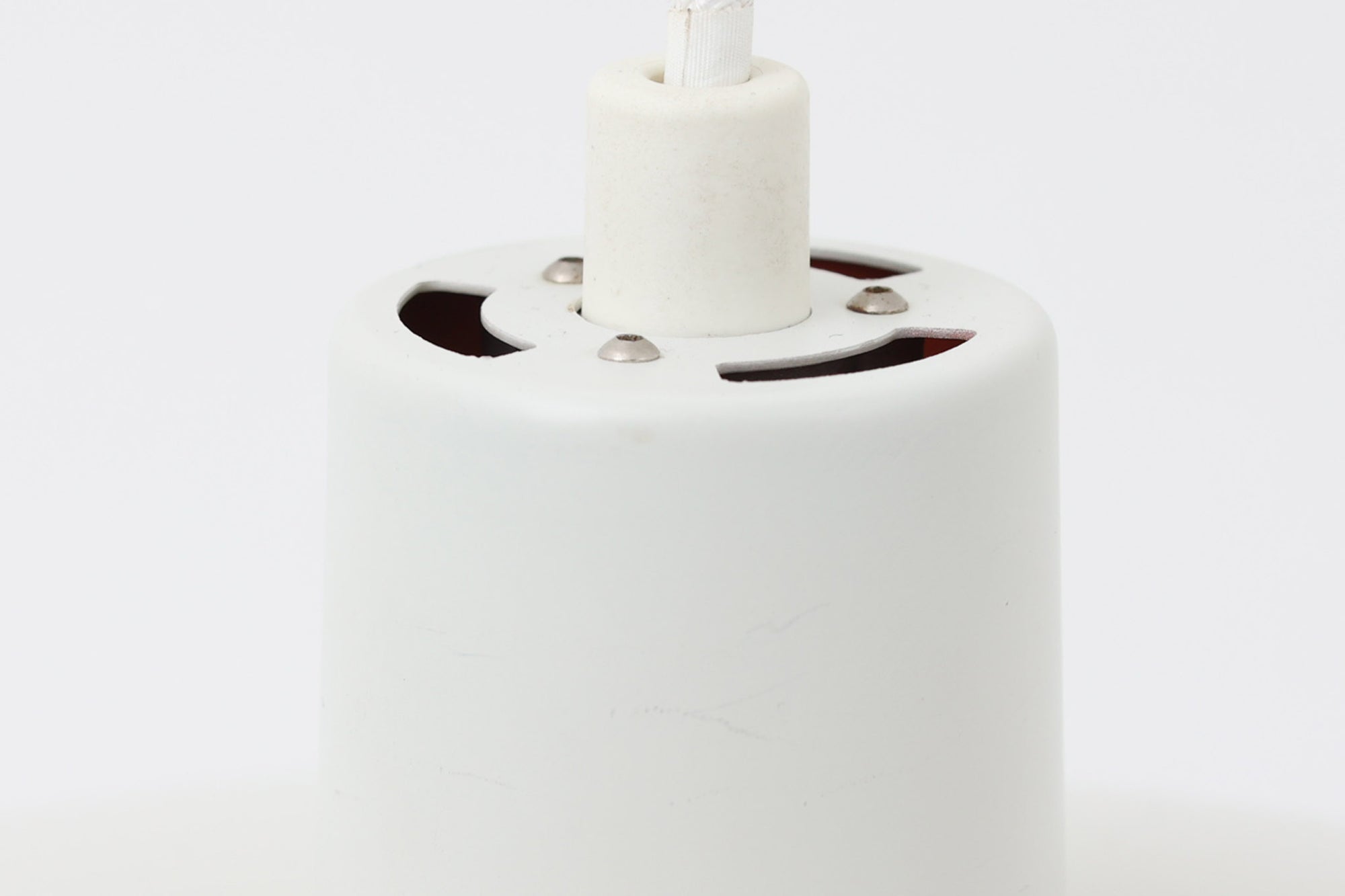 北欧照明の巨匠Poul Henningsenによってデザインされた「PH4」ペンダントライト。Louis Poulsen社製で、光を効率よく拡散させる3枚シェード構造が特徴。内側にオレンジのリフレクターを備えており、暖かく落ち着いた光を演出します。シェード表面には経年に伴う擦れや細かい傷、塗装の薄れが見られますが、ビンテージらしい味わいを感じられる一品です。リビングやダイニング、カウンター上などにおすすめのサイズ感です。