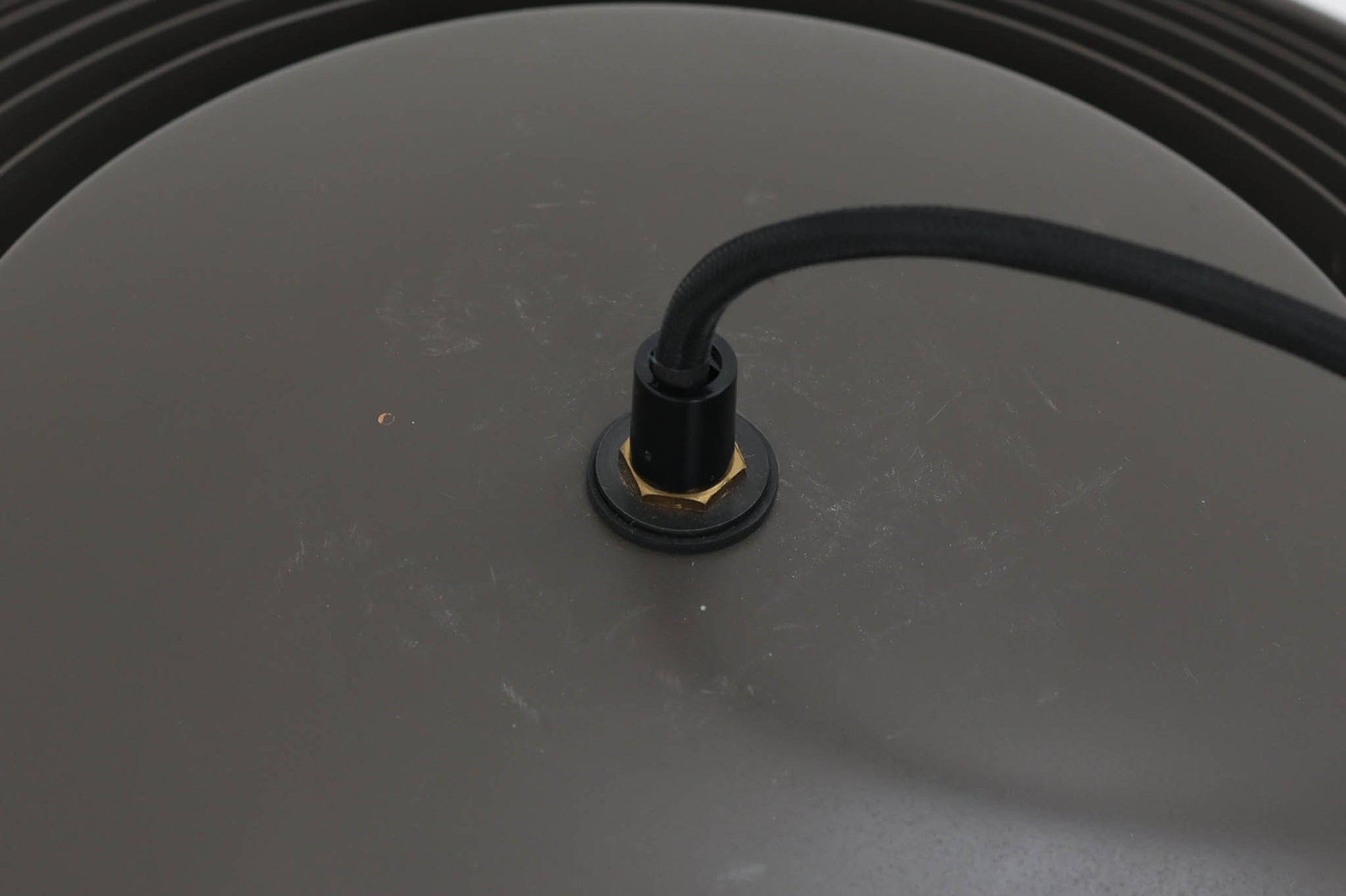 アルネ・ヤコブセンによってデザインされ、Louis Poulsen（ルイスポールセン）より製造されたAJロイヤル ペンダントライト。こちらは希少なグラファイトグレーカラーで、落ち着いたトーンが空間にシックな雰囲気を演出します。直径50cmの大型サイズで、光源を遮る構造と放射状に配置されたルーバーにより、眩しさを抑えた柔らかい光が空間全体を包み込みます。点灯時には上部のスリットから漏れる光も美しく、デザイン性と機能性を兼ね備えた一品です。外観には小傷や使用感がありますが、ビンテージならではの風合いとしてお楽しみいただけます。