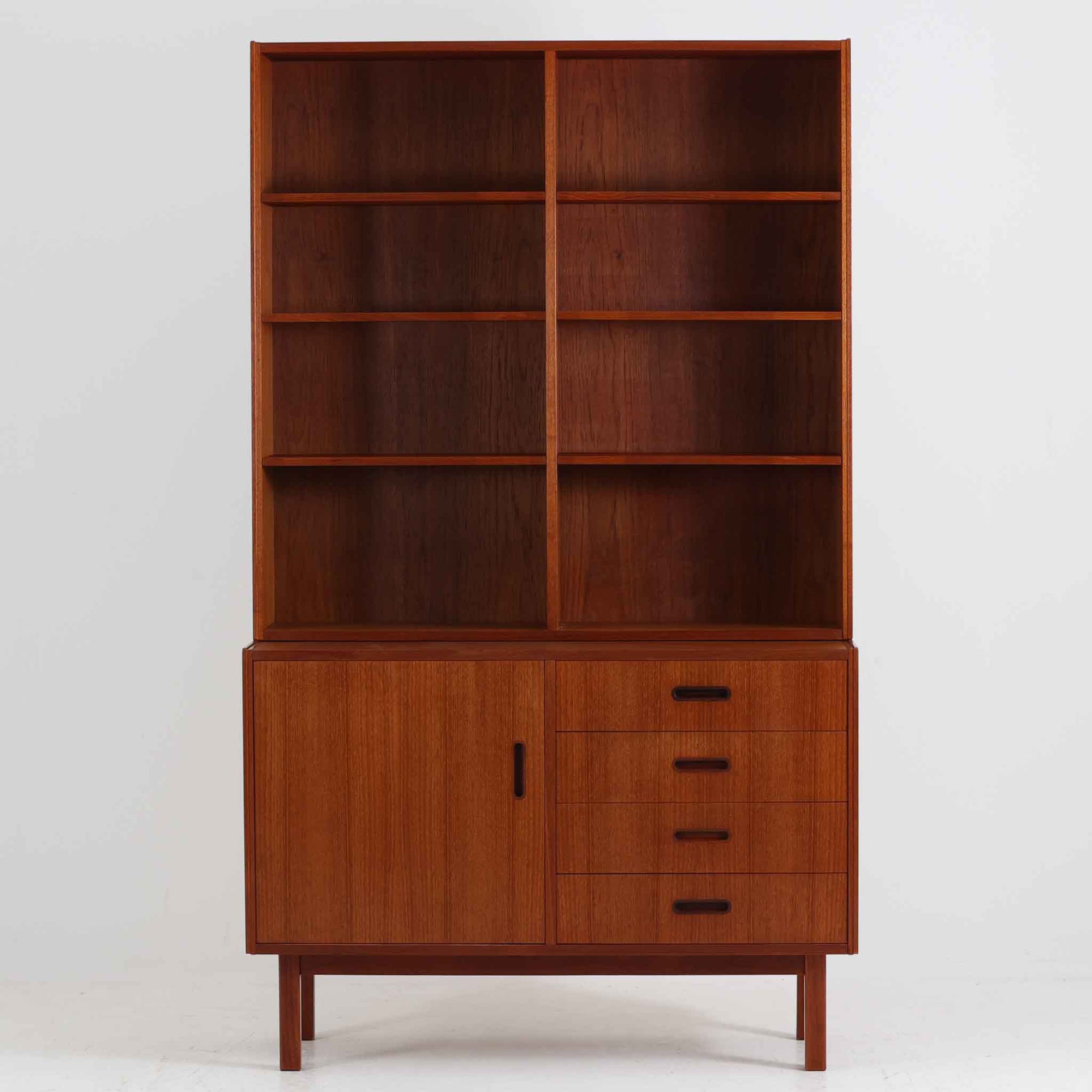 チーク材を使用したスウェーデン製のディスプレイシェルフです。上段は収納力のある可動棚付きのオープンスペース、下段には引き出し4杯と扉収納が備えられており、実用性とデザイン性を兼ね備えた構成です。シンプルな取手の意匠や直線的な脚部が北欧家具らしい洗練を感じさせ、経年により深みを増したチークの色合いが空間に温かみを与えます。リビングや書斎での本や雑貨の収納・展示におすすめのビンテージアイテムです。