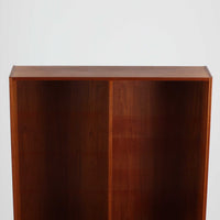 チーク材を使用したスウェーデン製のディスプレイシェルフです。上段は収納力のある可動棚付きのオープンスペース、下段には引き出し4杯と扉収納が備えられており、実用性とデザイン性を兼ね備えた構成です。シンプルな取手の意匠や直線的な脚部が北欧家具らしい洗練を感じさせ、経年により深みを増したチークの色合いが空間に温かみを与えます。リビングや書斎での本や雑貨の収納・展示におすすめのビンテージアイテムです。