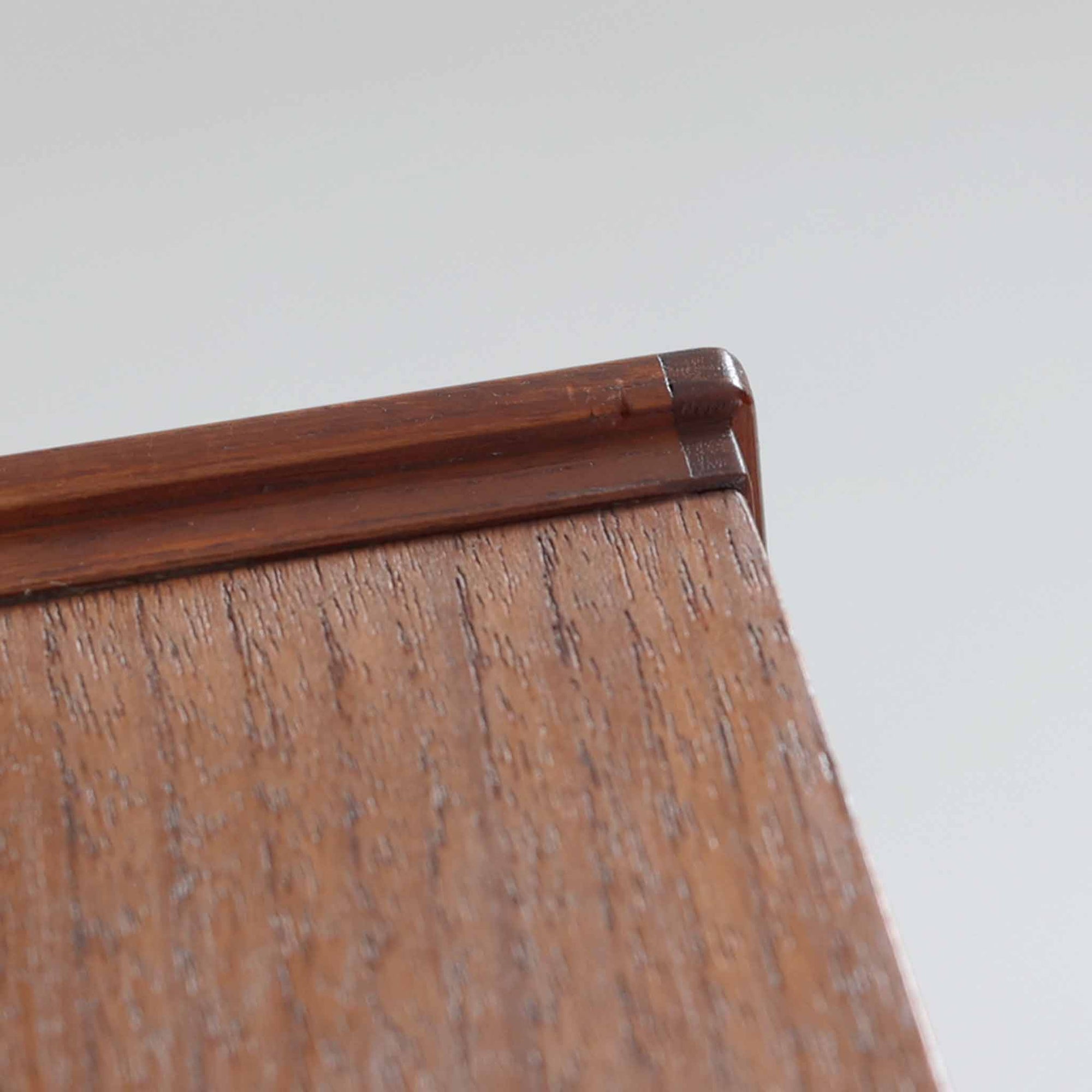 チーク材を使用したスウェーデン製のディスプレイシェルフです。上段は収納力のある可動棚付きのオープンスペース、下段には引き出し4杯と扉収納が備えられており、実用性とデザイン性を兼ね備えた構成です。シンプルな取手の意匠や直線的な脚部が北欧家具らしい洗練を感じさせ、経年により深みを増したチークの色合いが空間に温かみを与えます。リビングや書斎での本や雑貨の収納・展示におすすめのビンテージアイテムです。