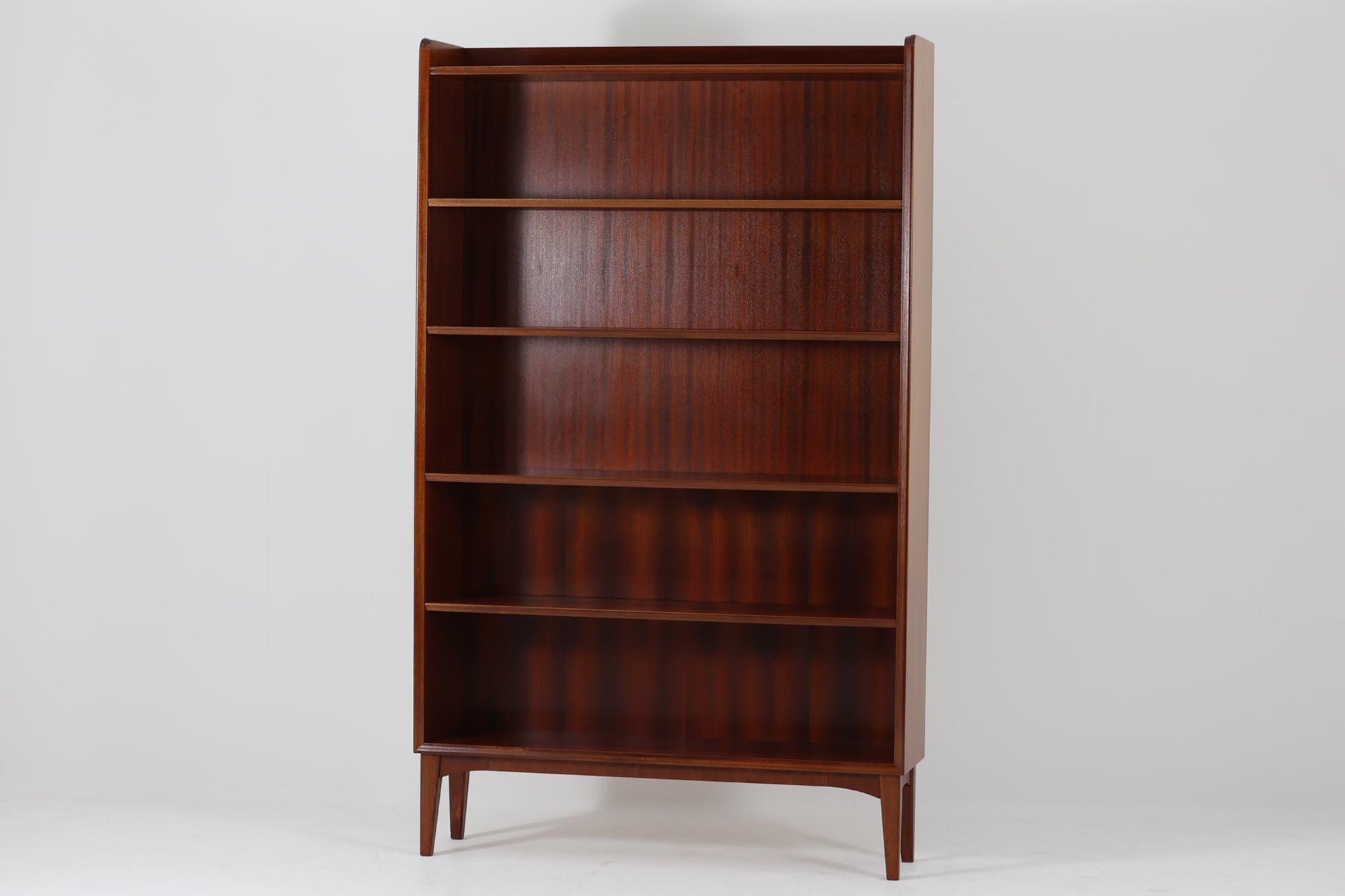 スウェーデンで製造されたヴィンテージのブックシェルフ。高級感のあるマホガニー材を使用し、深みのある美しい木目が魅力です。シンプルで洗練されたデザインながら、細部にまでこだわりを感じさせる一品。スリムなシルエットながらも収納力に優れ、本や雑貨をすっきりと収納できます。脚部には優雅なカーブが施され、北欧家具らしい軽やかな印象を与えています。リビングや書斎、寝室などさまざまな空間に溶け込み、シックで上品な雰囲気を演出するブックシェルフです。北欧ヴィンテージ家具ならではの味わいをお楽しみください。