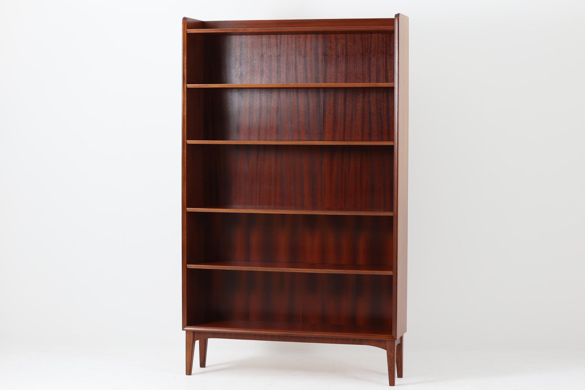 スウェーデンで製造されたヴィンテージのブックシェルフ。高級感のあるマホガニー材を使用し、深みのある美しい木目が魅力です。シンプルで洗練されたデザインながら、細部にまでこだわりを感じさせる一品。スリムなシルエットながらも収納力に優れ、本や雑貨をすっきりと収納できます。脚部には優雅なカーブが施され、北欧家具らしい軽やかな印象を与えています。リビングや書斎、寝室などさまざまな空間に溶け込み、シックで上品な雰囲気を演出するブックシェルフです。北欧ヴィンテージ家具ならではの味わいをお楽しみください。